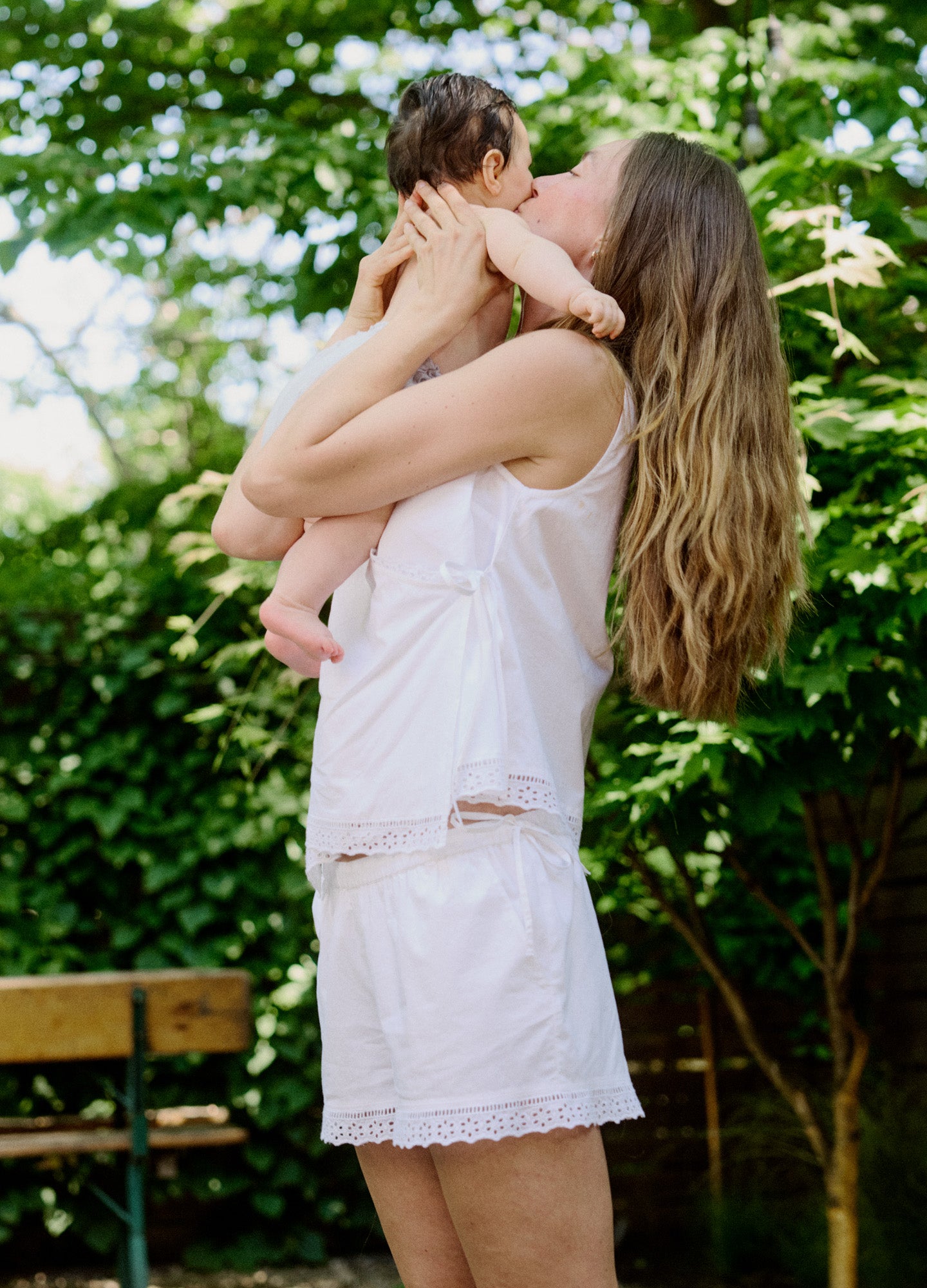 White sleeveless nursing top with side ruching paired with matching lace-trimmed shorts.