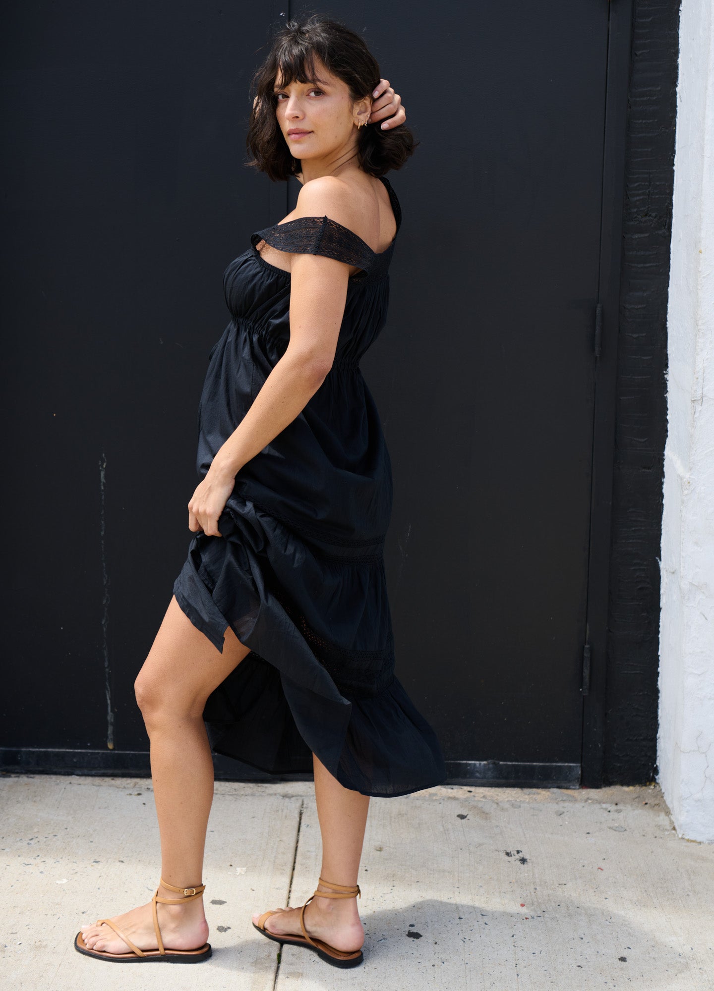 Black off-shoulder maternity dress with ruched waist and flowy midi skirt.