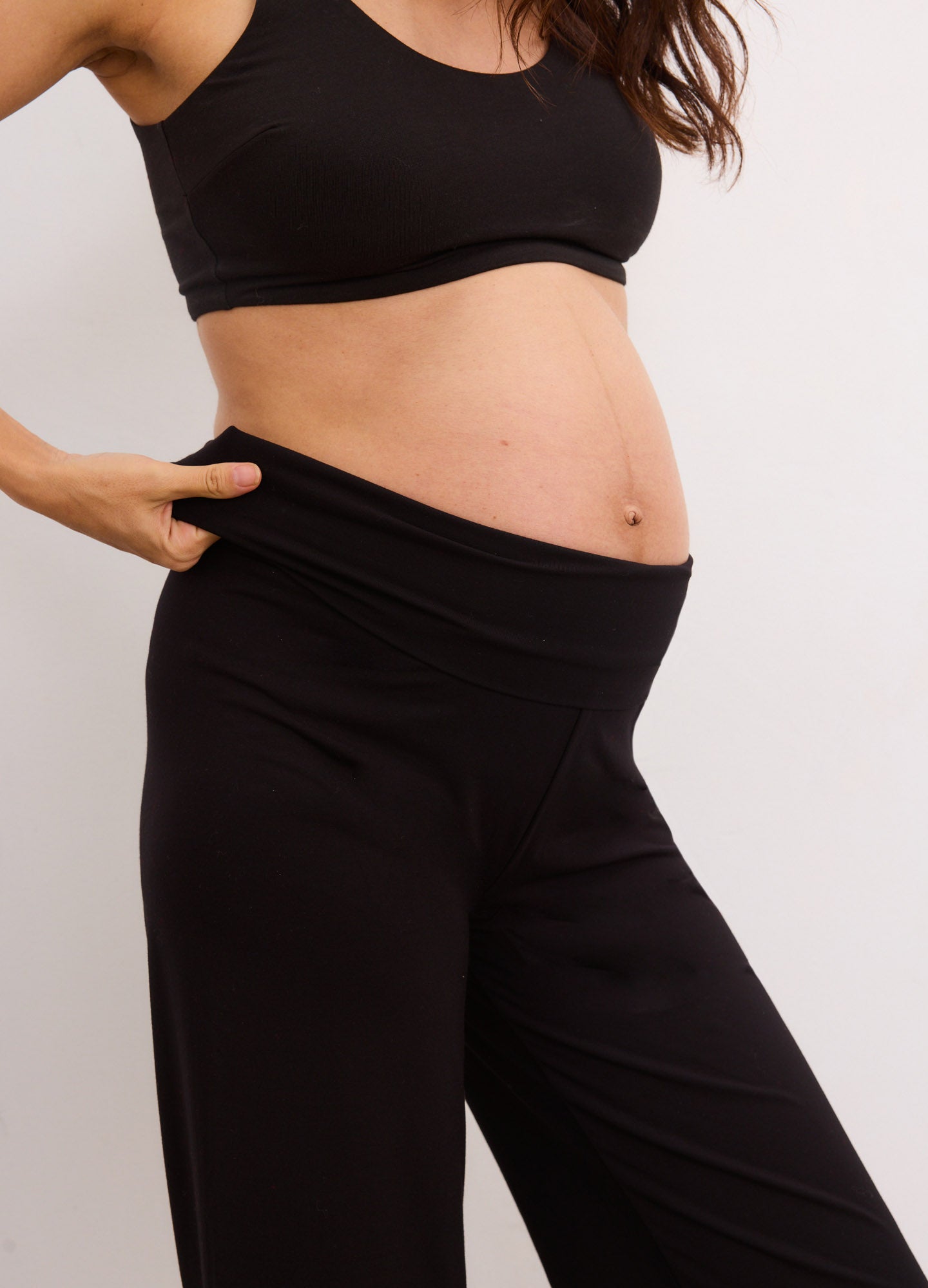 Black high-waisted maternity crop pants with stretchy fabric and a snug, comfortable fit designed for pregnancy.