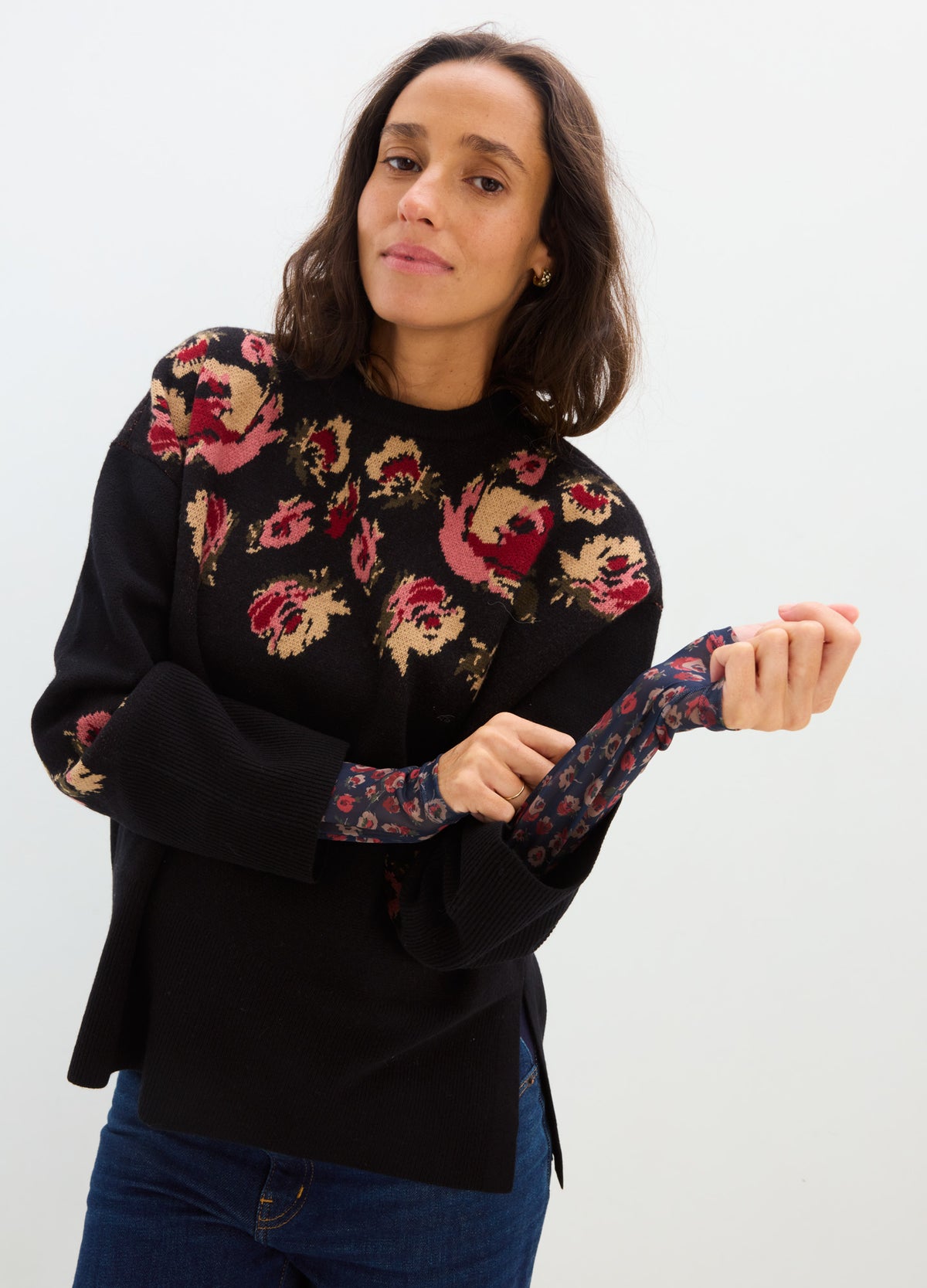 Black maternity sweater with colorful floral embroidery across the chest and sleeves, modeled with a relaxed fit.