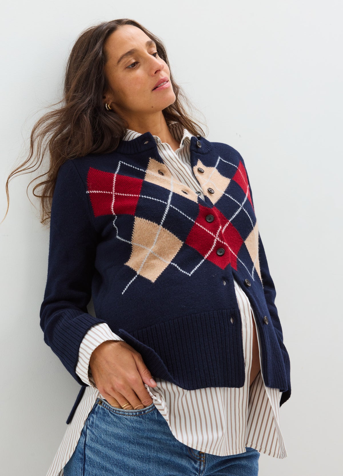 Navy blue maternity cardigan with red and beige argyle pattern, worn over striped shirt.