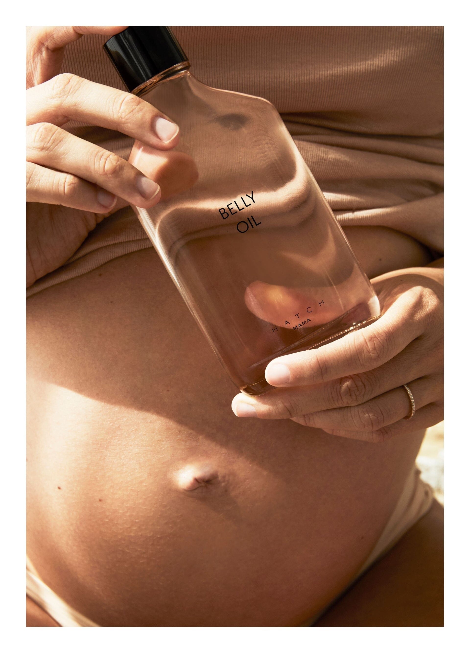 Belly Oil (Copy) - Clear glass bottle of maternity belly oil with soft pink liquid, designed for pregnancy, nursing, and postpartum care next.