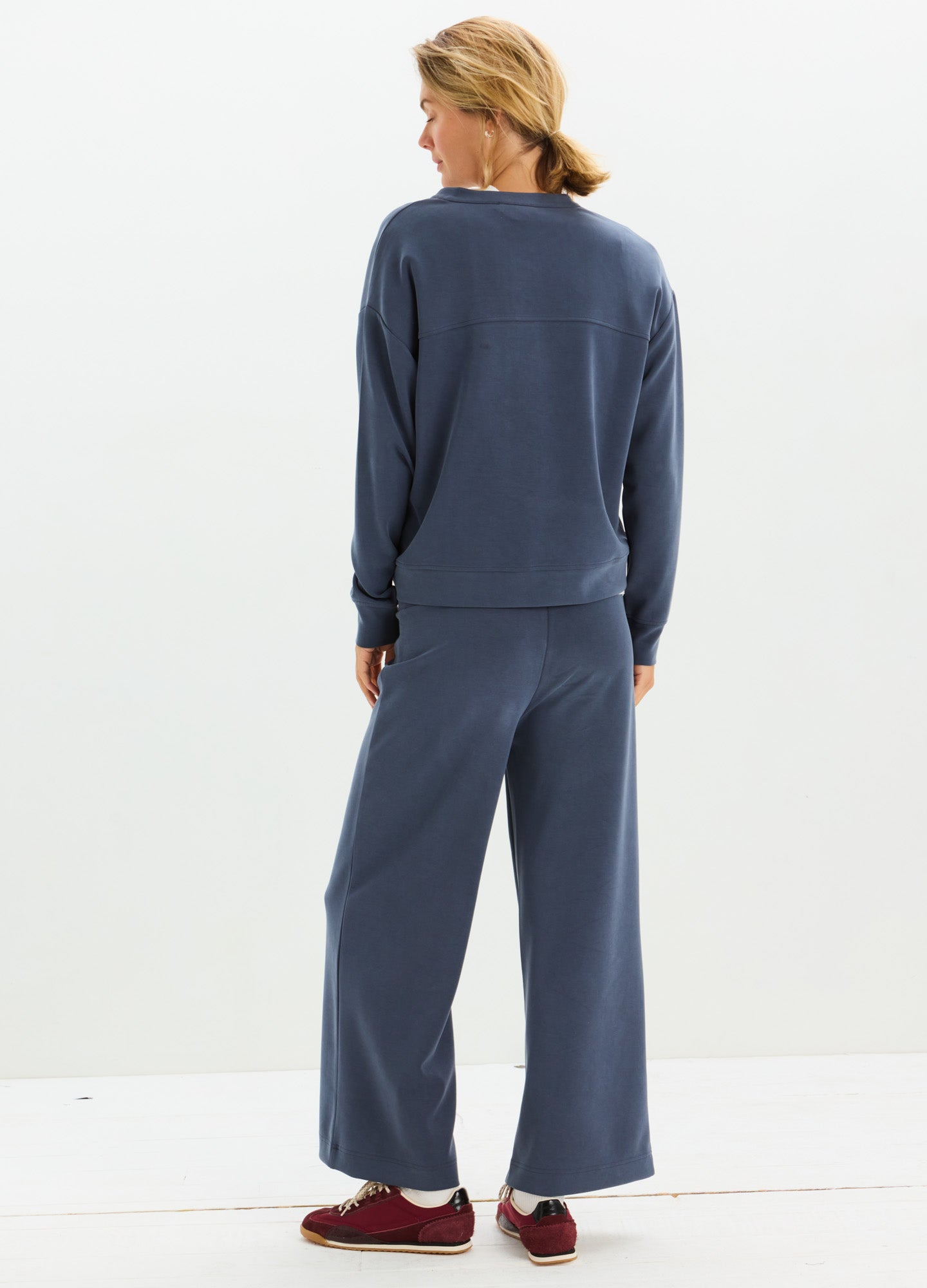 Navy blue loose-fit maternity pants with wide legs and soft fabric, styled with matching long-sleeve top.