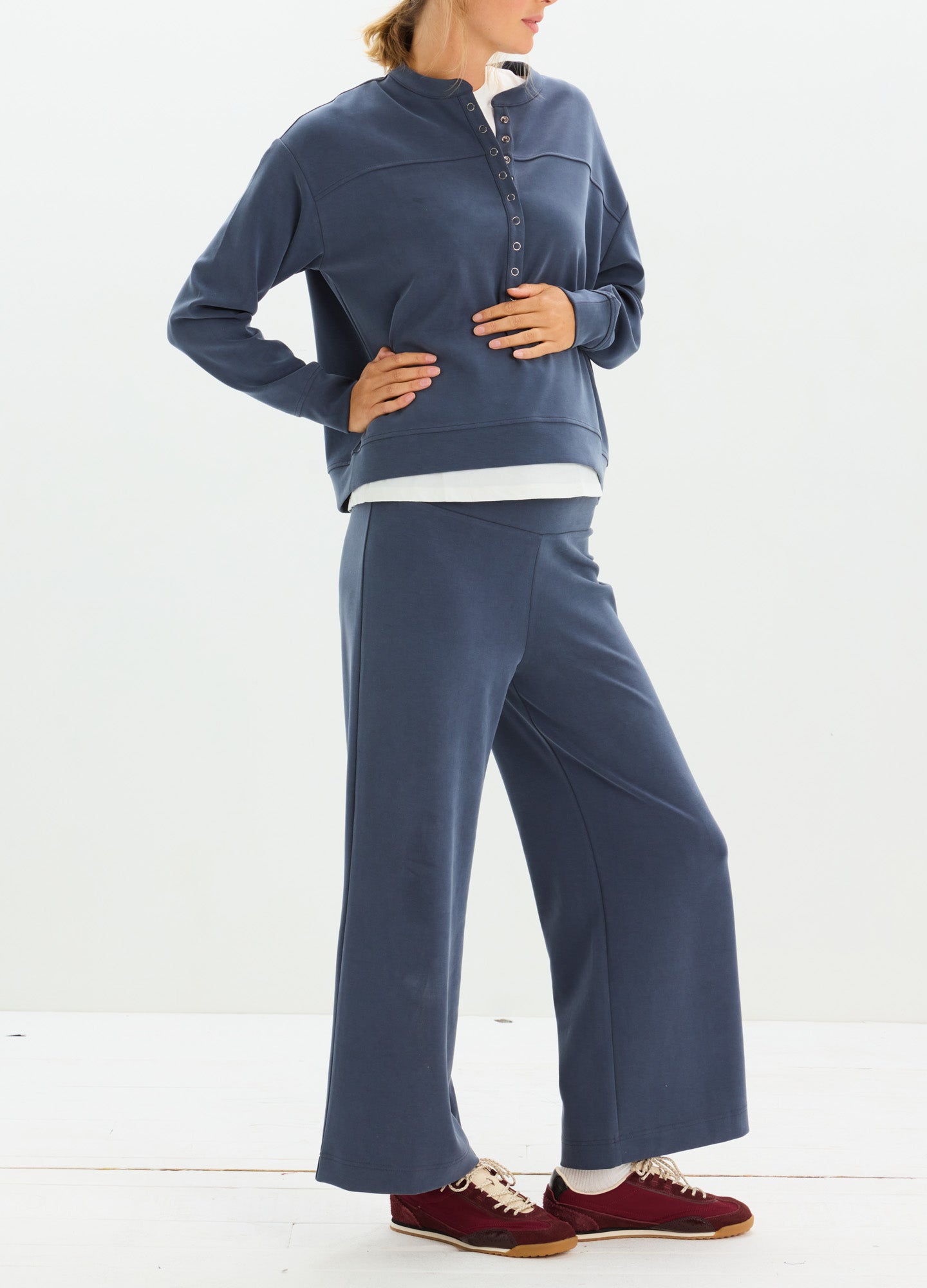 Navy blue maternity pullover with buttoned collar and matching wide-leg pants worn by pregnant model.