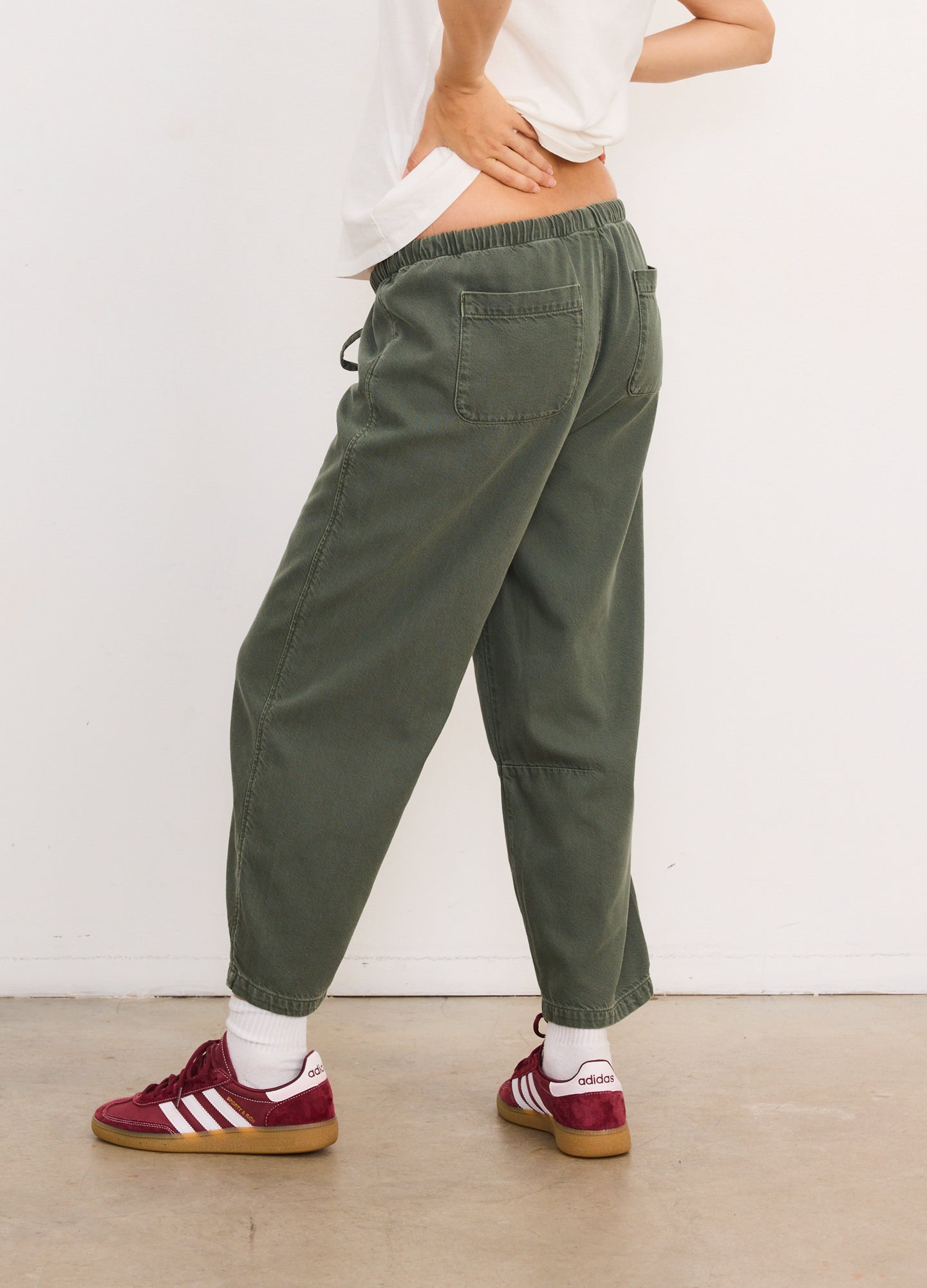 Olive green drapey denim maternity barrel pants with elastic waistband and relaxed fit.