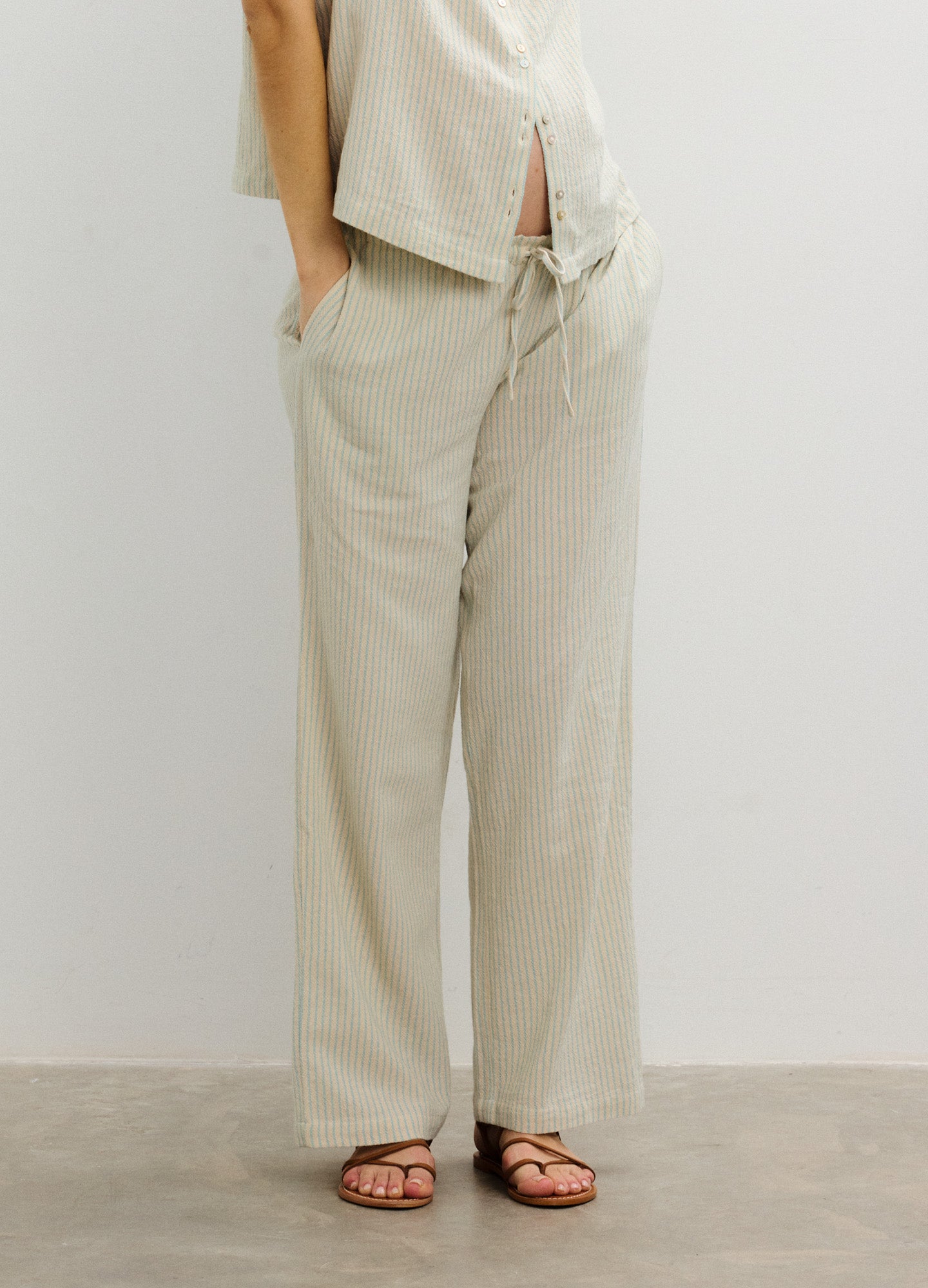 Light beige maternity pants with wide legs, adjustable drawstring waist, and soft fabric tailored for pregnant women.