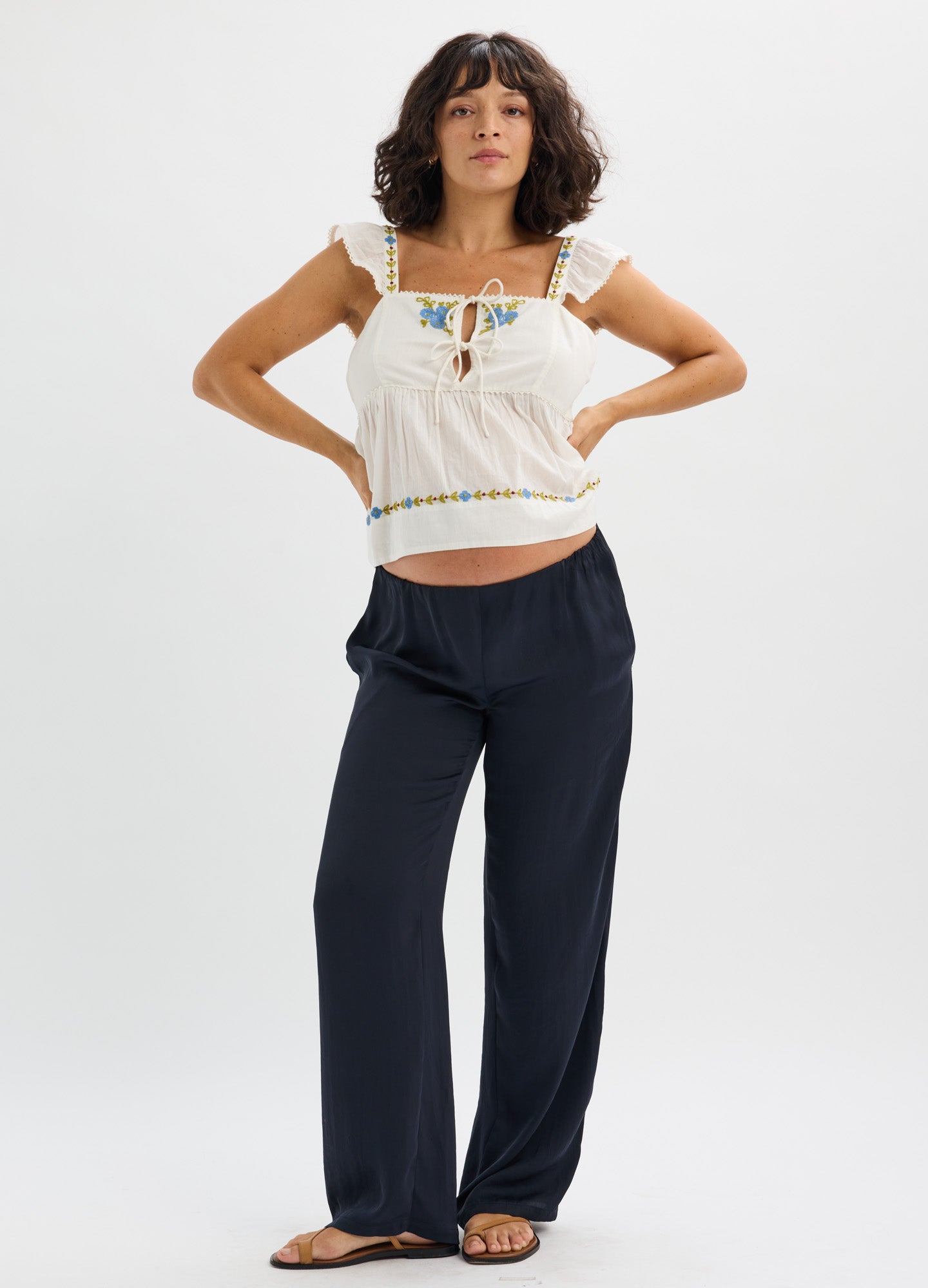 Navy blue wide-leg knit maternity pants with elastic waistband worn by model in white sleeveless top.