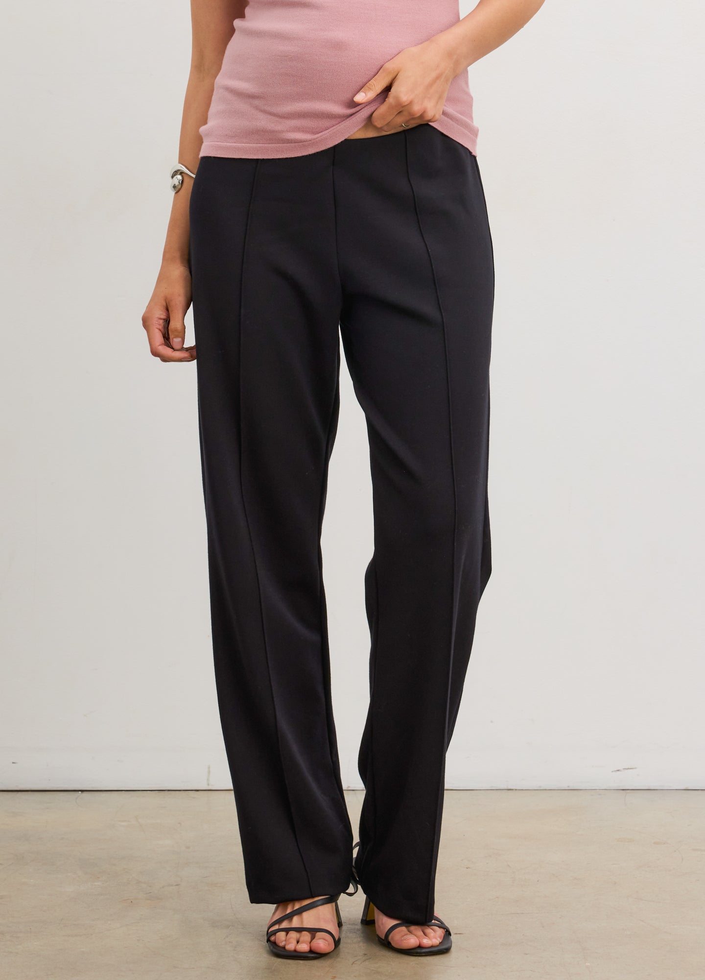 Black straight-leg maternity pants with seamed front and stretchy waistband, worn by pregnant model.