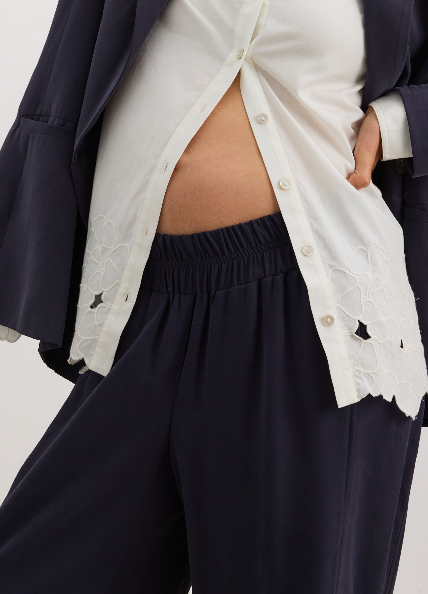 Black maternity pull-on trousers with elastic waistband, soft tailored fit, paired with white buttoned top and navy blazer.