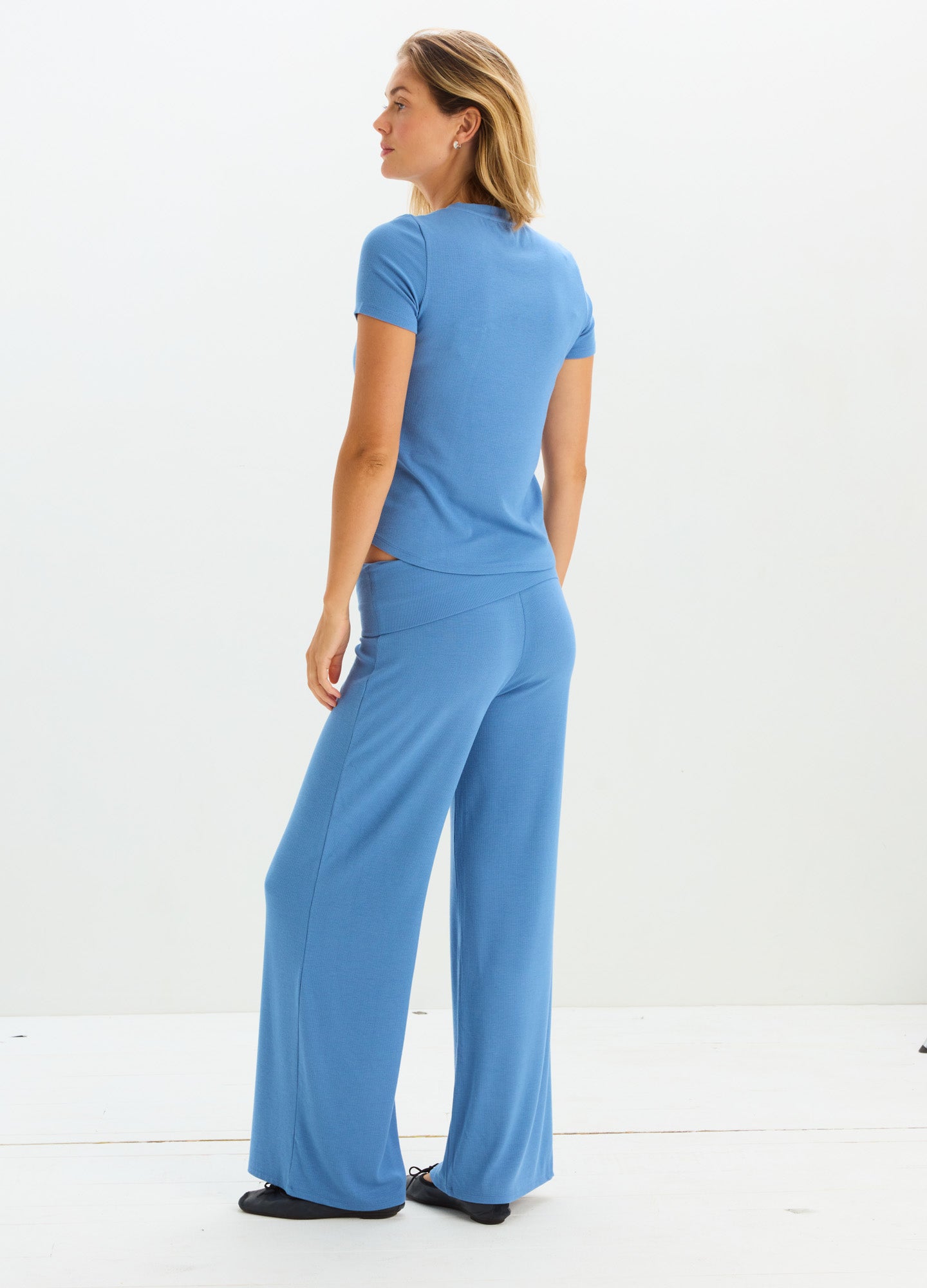 Soft blue rib-knit maternity pants with relaxed wide legs worn with short-sleeve fitted top.