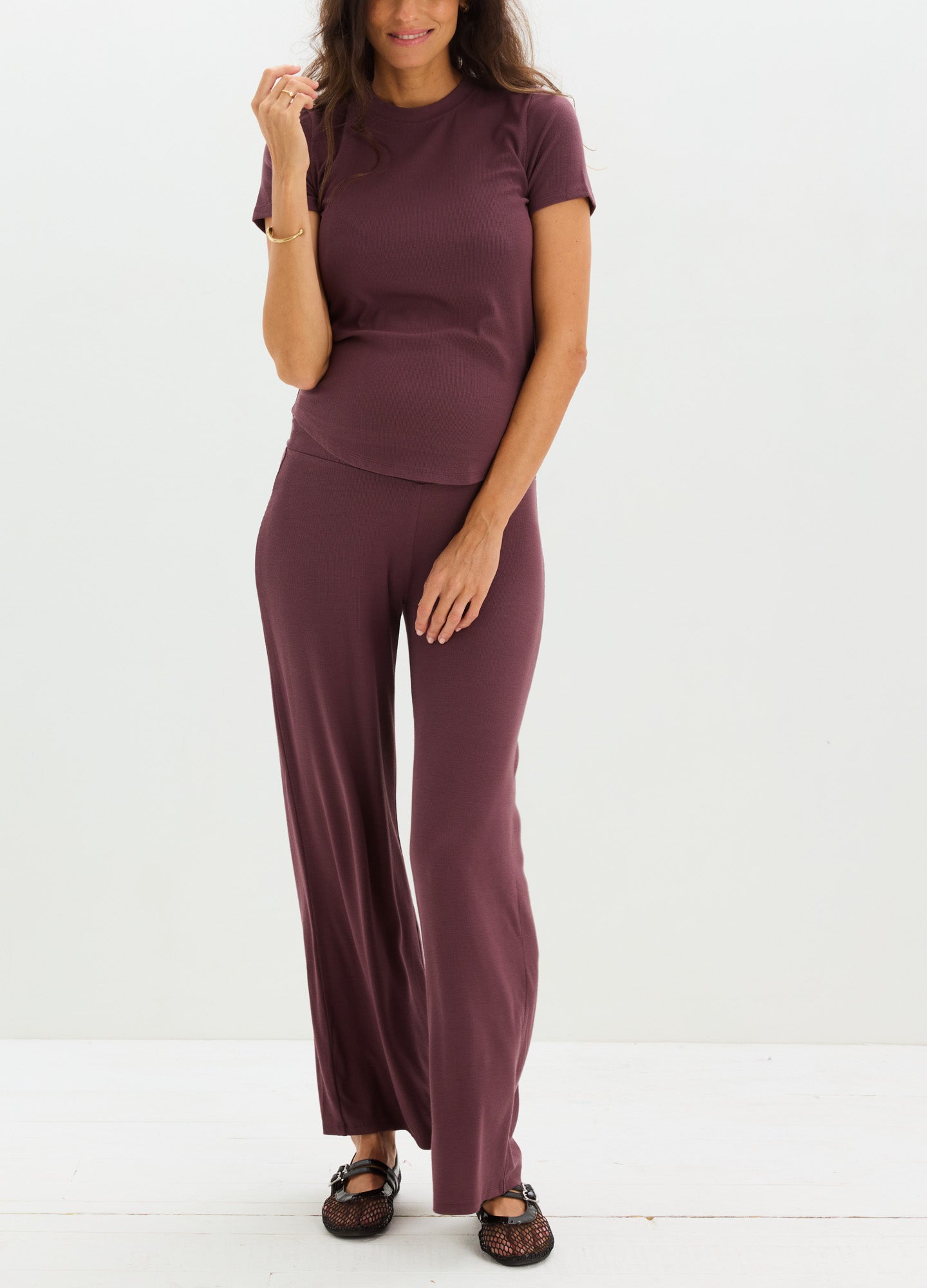 Soft ribbed maternity tee in deep plum with short sleeves and fitted silhouette tailored for pregnant bodies.
