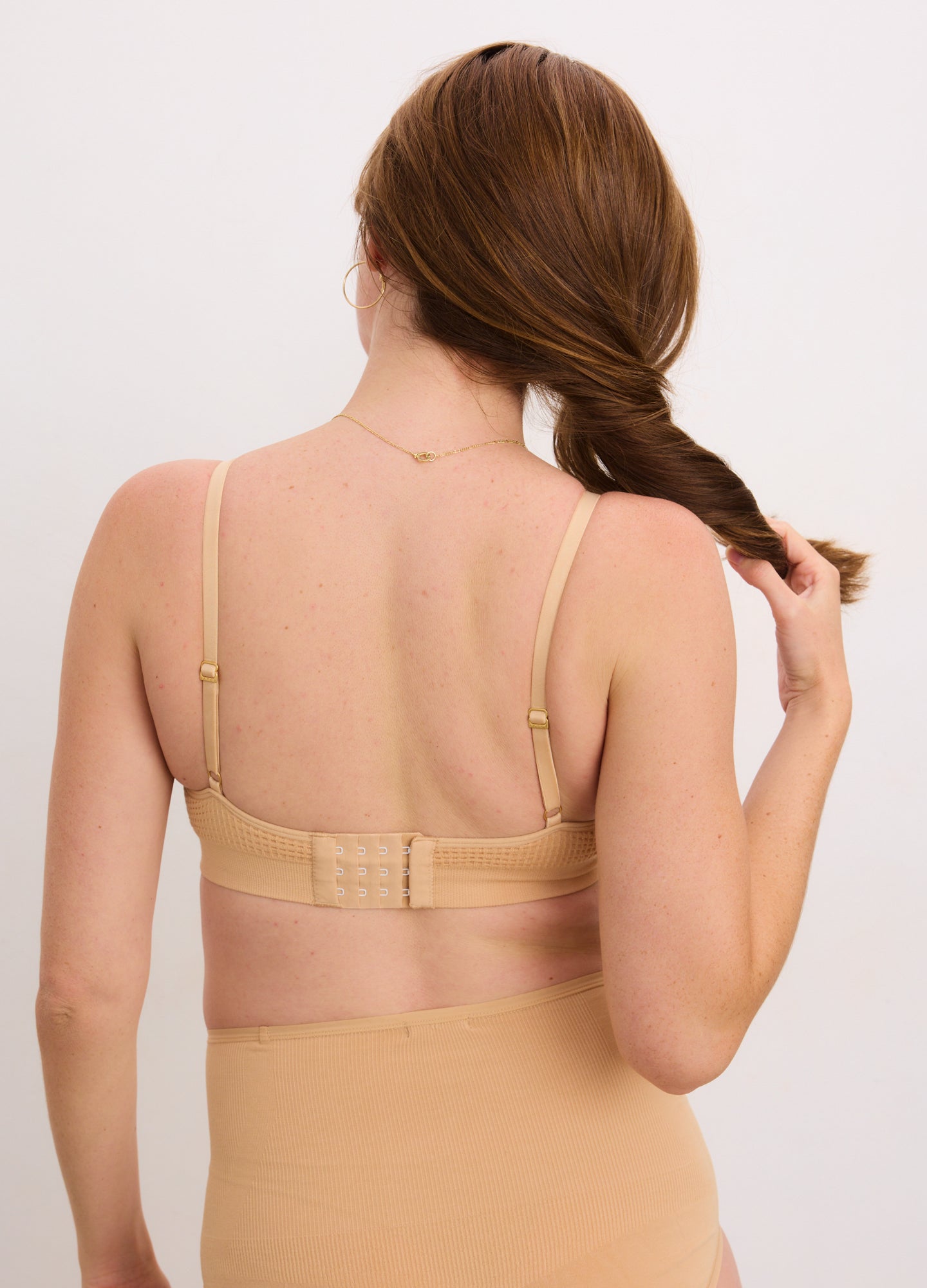 Beige maternity bra with adjustable thin straps and a multi-hook back closure designed for pregnant women.