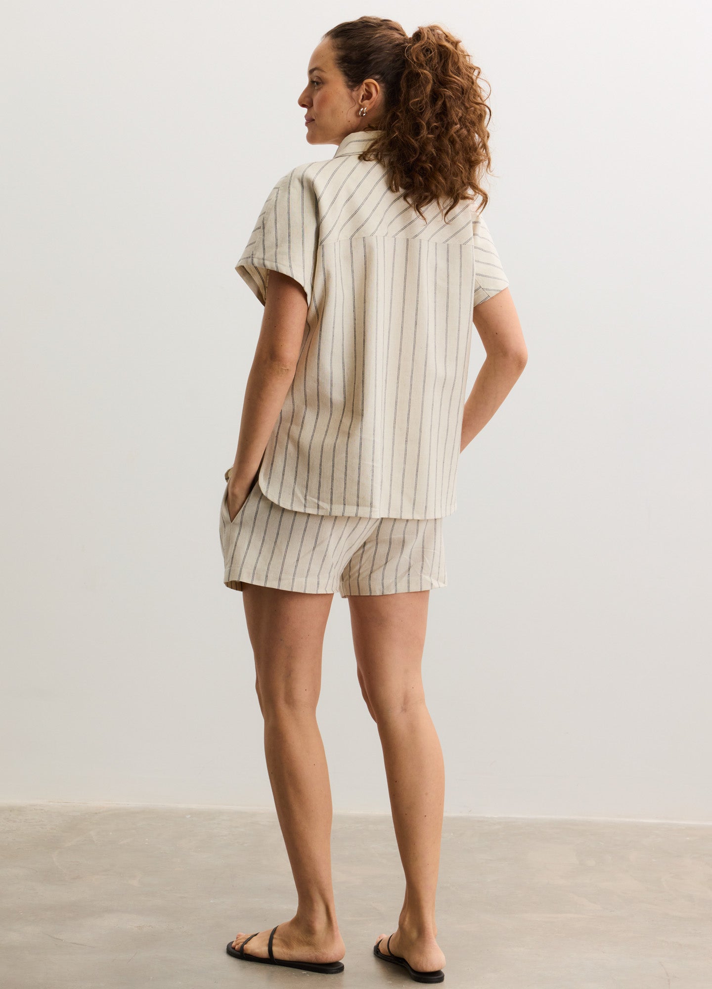 Beige and white striped loose-fit short-sleeve maternity shirt paired with matching relaxed shorts.