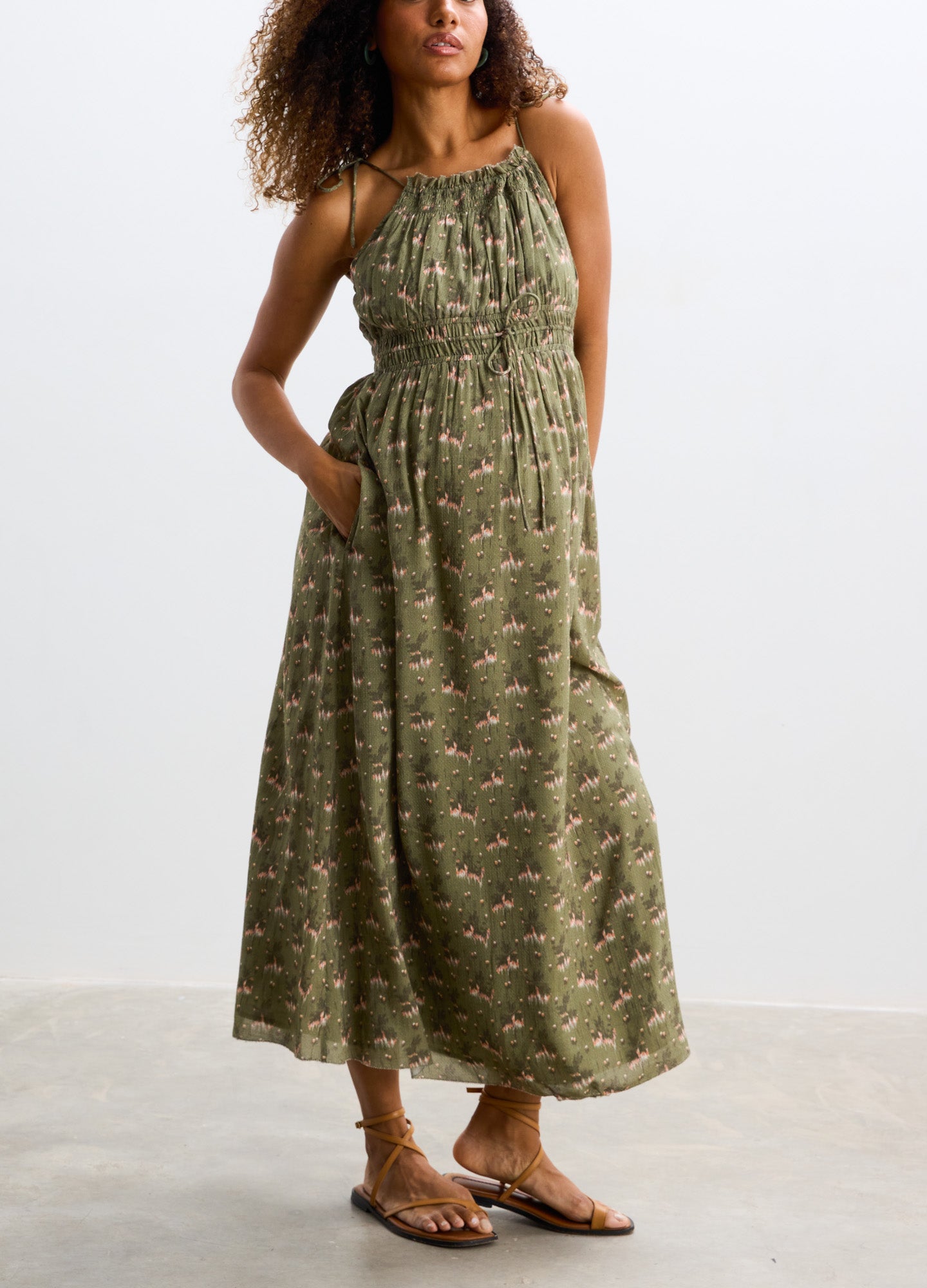 Olive green sleeveless maternity maxi dress with subtle floral print and gathered neckline.