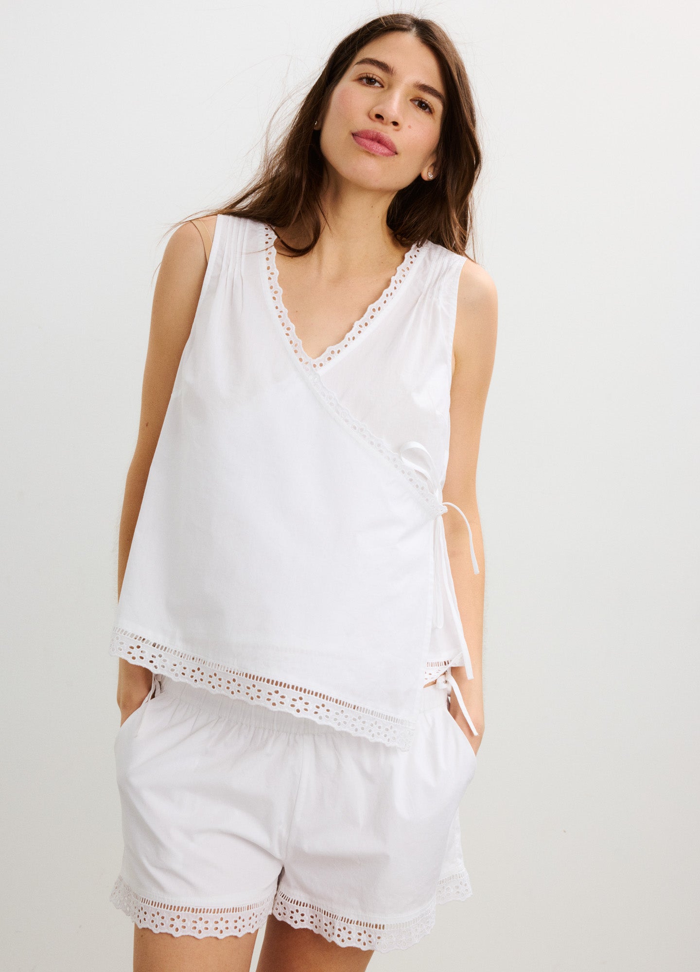 White sleeveless maternity nursing top with lace trim, paired with matching loose shorts.