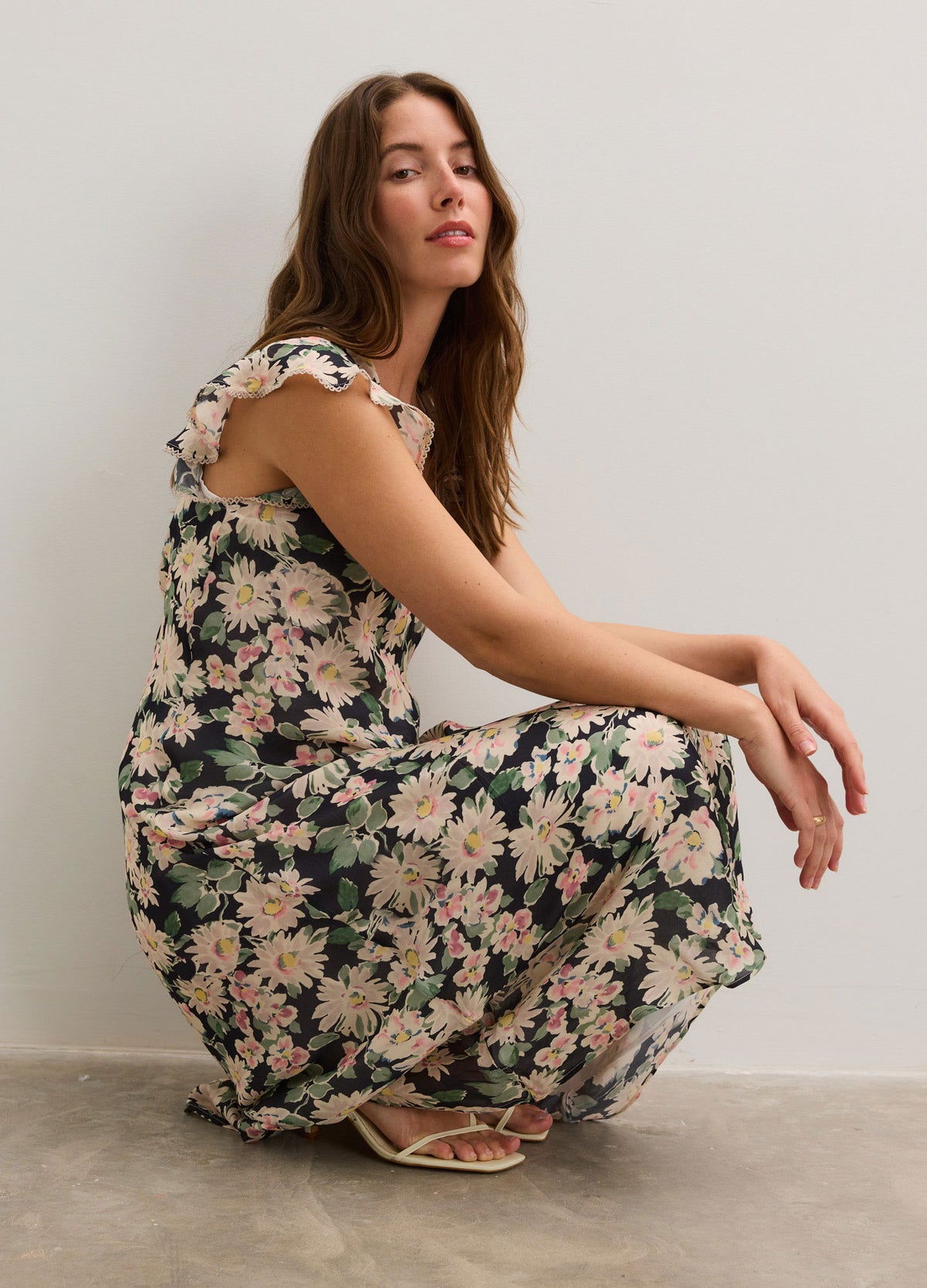 Floral maternity dress with capped sleeves and a flowing, ankle-length skirt in soft pastel tones.