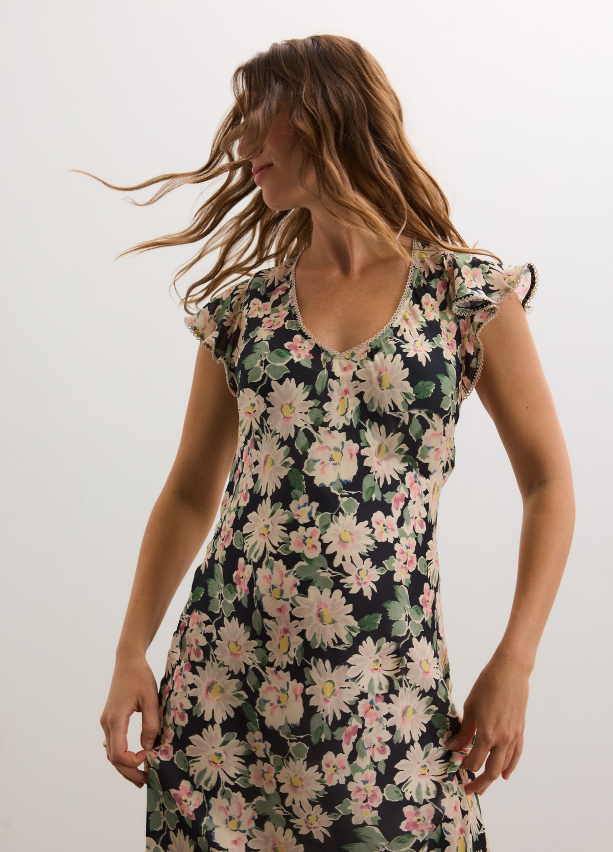 Black floral maternity dress with pink and white daisies, V-neck, and flutter sleeves.