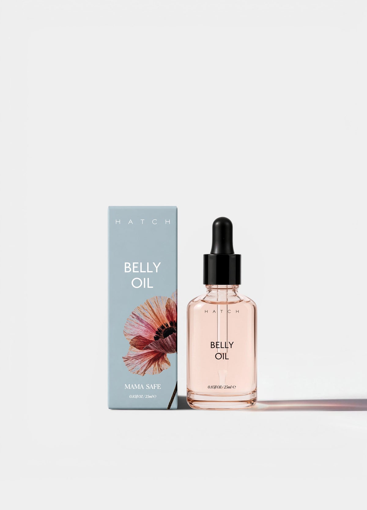 Clear glass dropper bottle with light pink belly oil and pale blue box featuring floral design and white text.