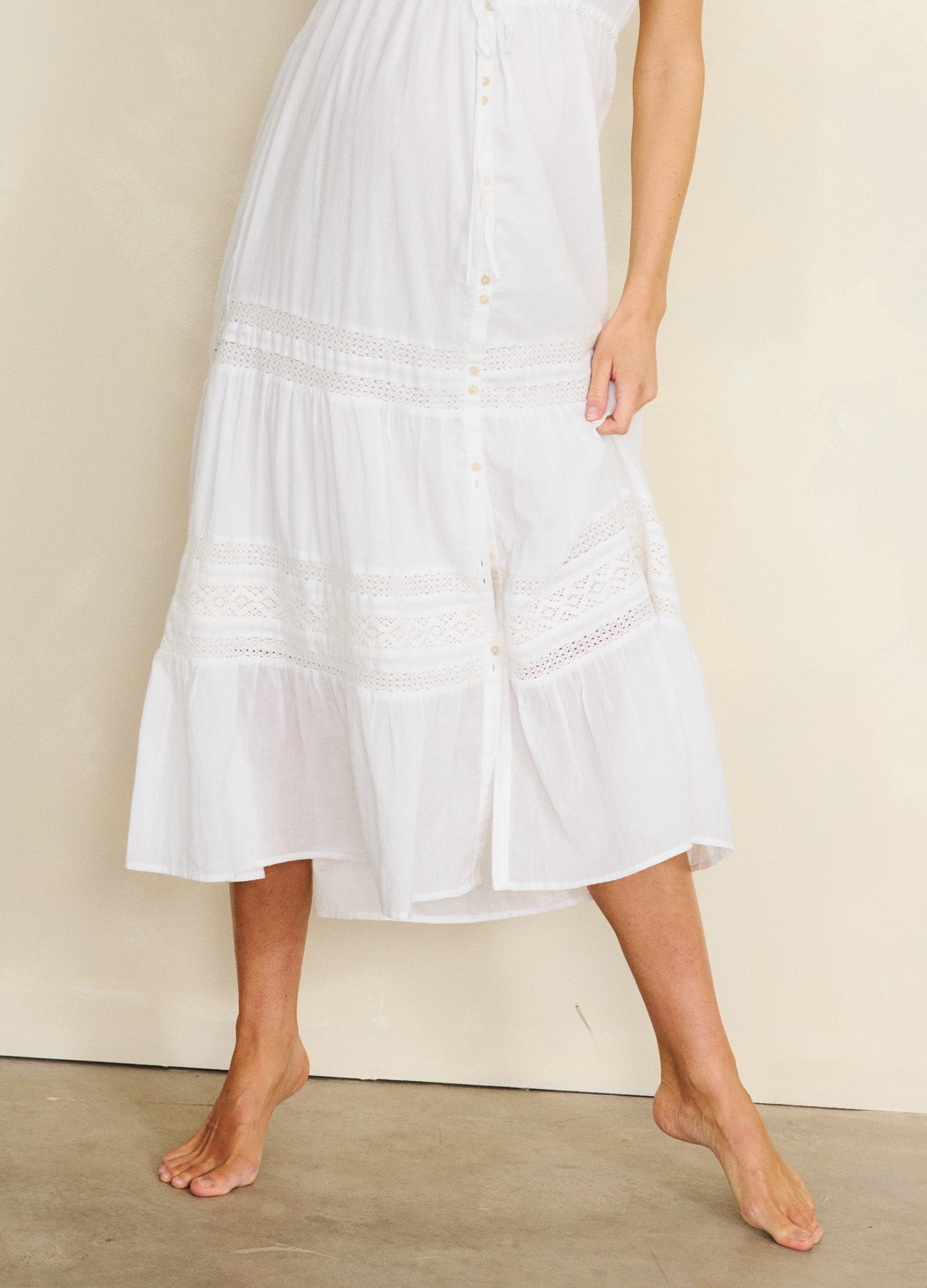White midi maternity dress with tiered skirt and button-front detail, lightweight fabric.