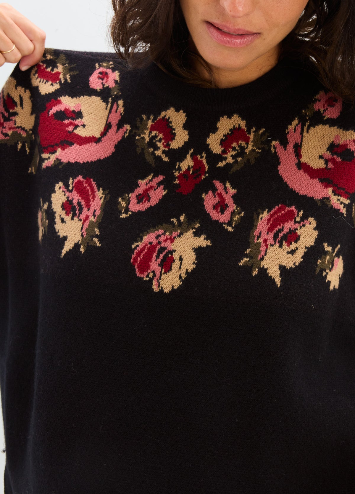 Black knit Briar sweater with pink and cream floral motifs, shown with a relaxed fit suitable for maternity wear.