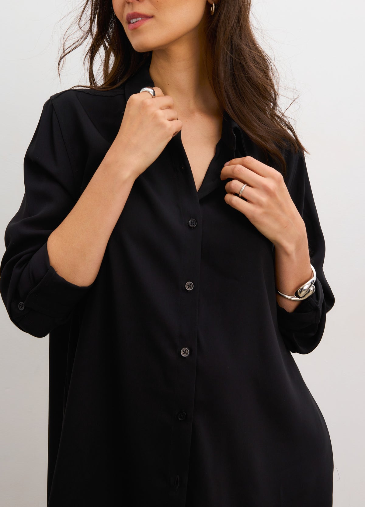 Black drapey maternity button-down shirt with long sleeves and relaxed fit.