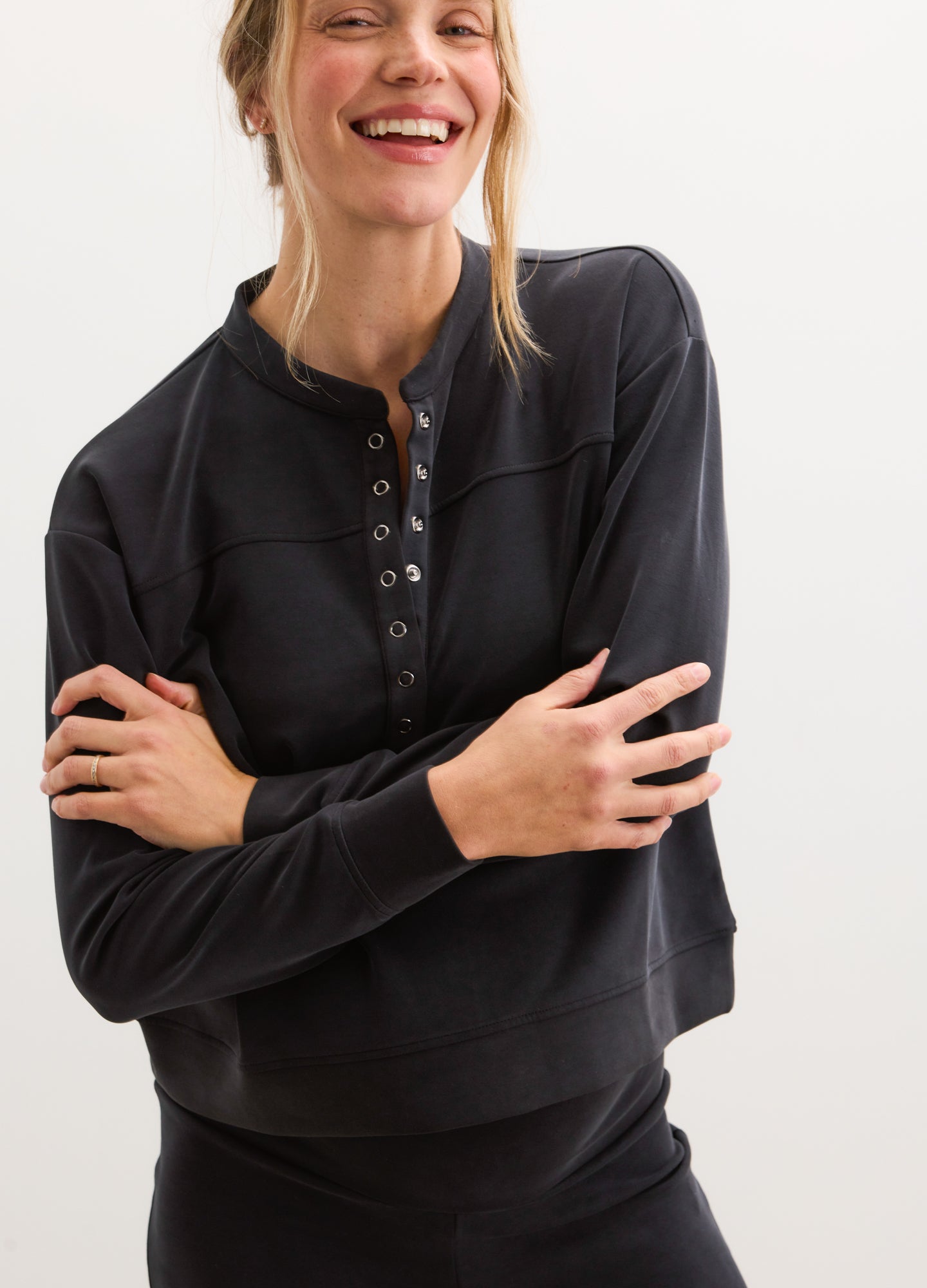 Black maternity pullover with long sleeves and buttoned henley neckline, relaxed fit.