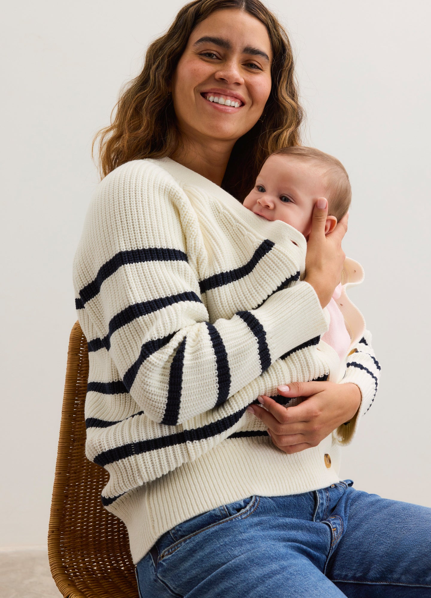 Cream cotton cardigan with navy horizontal stripes, ribbed cuffs and hem, worn by pregnant woman holding baby.