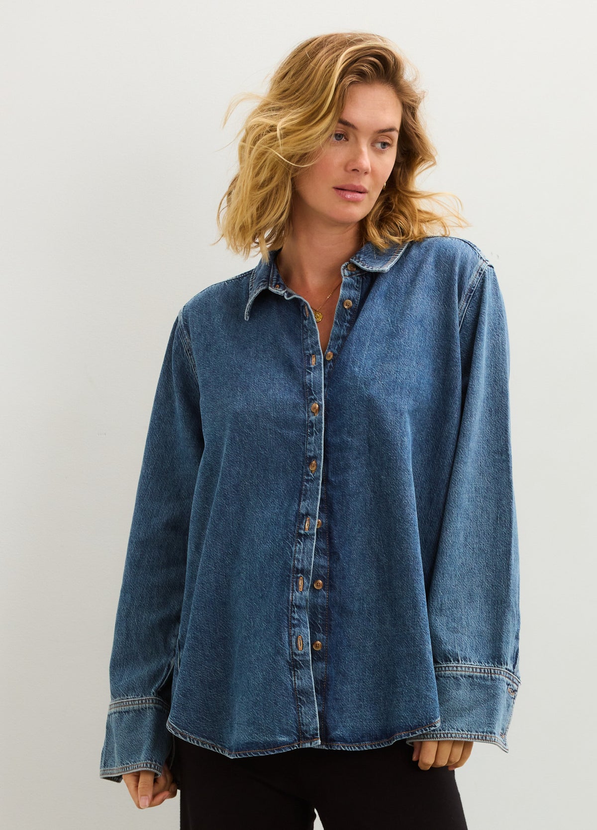 Soft drapey medium blue denim boyfriend shirt with button front, relaxed fit over pregnant belly.