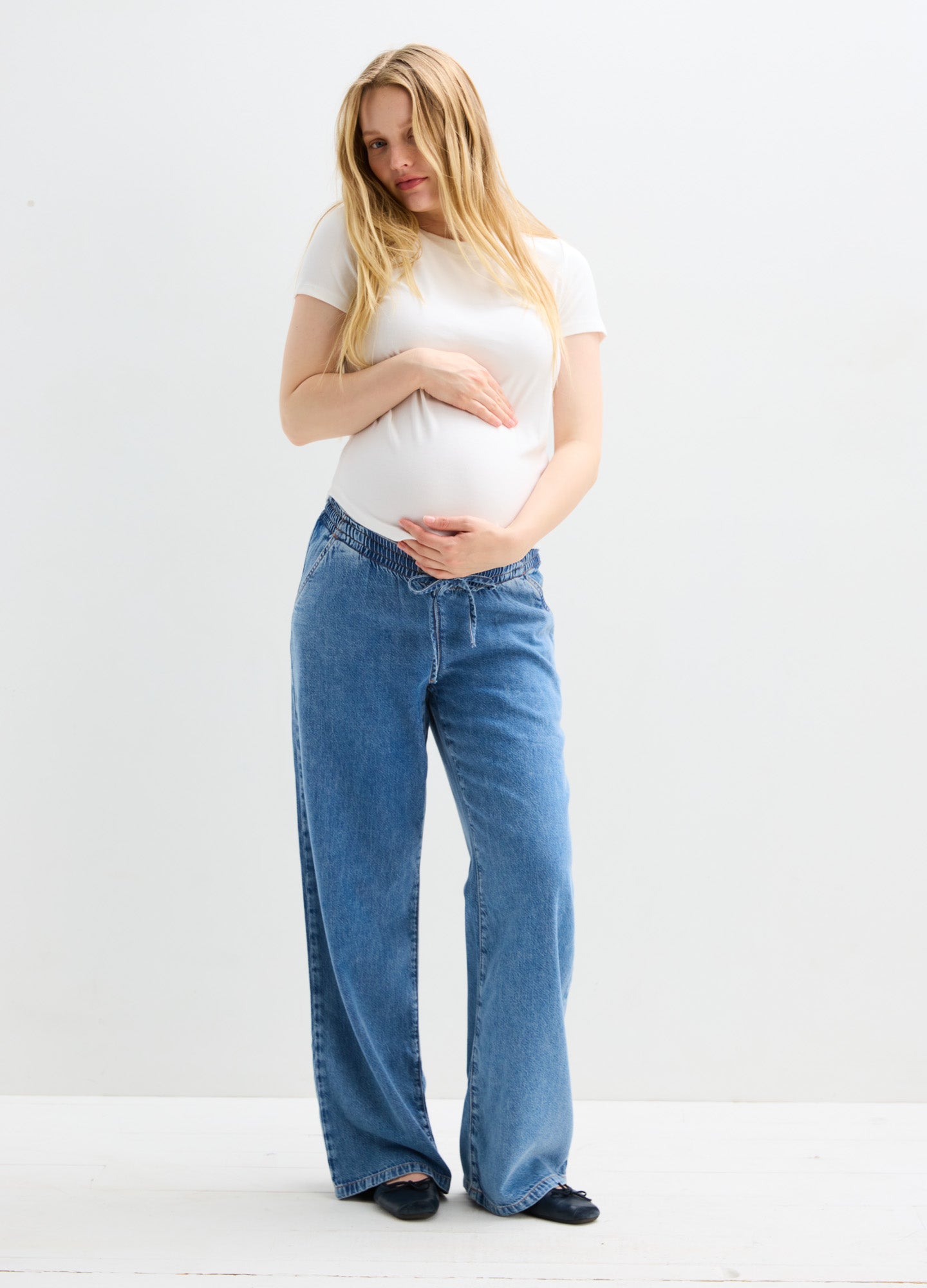 Blue wide-leg maternity jeans with a high, stretchy waistband designed for pregnant women.