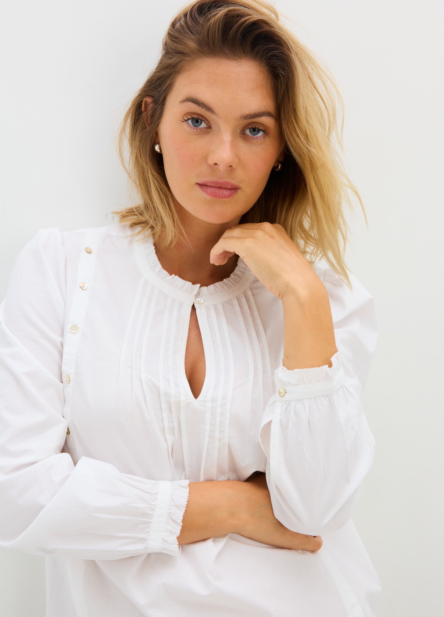 White maternity nursing blouse with long puff sleeves, button details, and keyhole neckline.