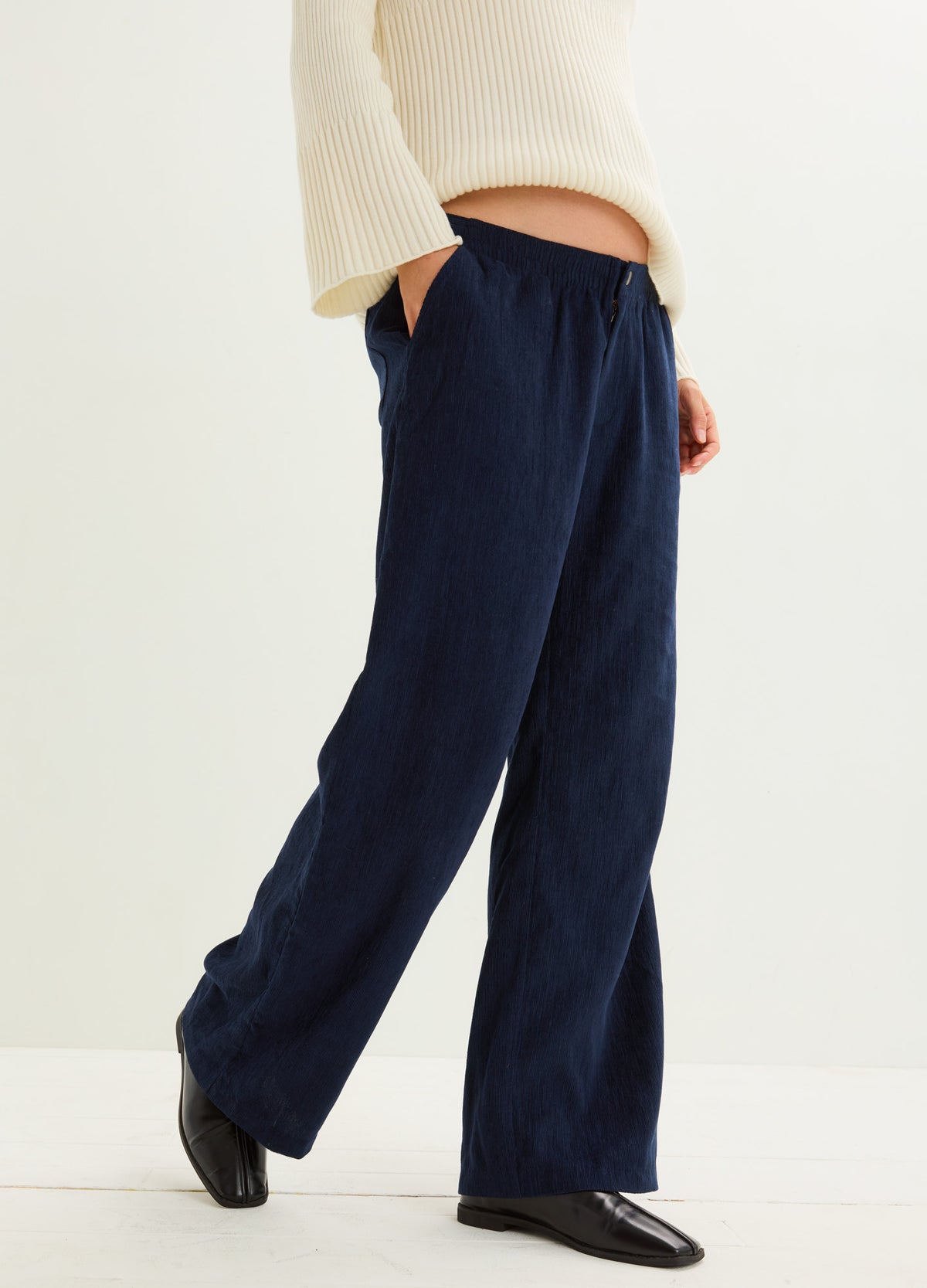 Navy corduroy pants with a relaxed wide-leg fit, elastic waistband, and side pockets.