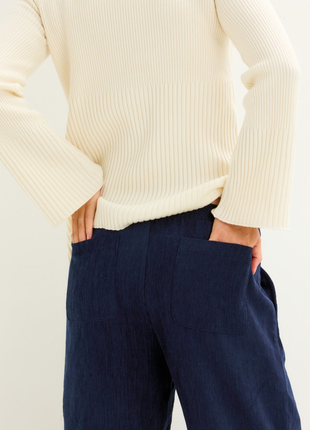 Navy corduroy maternity pants with a relaxed fit and roomy pockets, styled for pregnancy comfort.