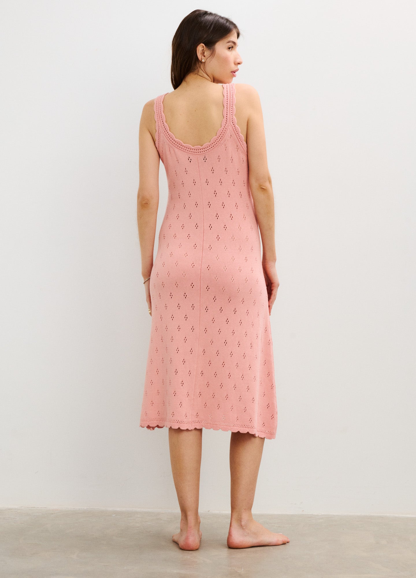 Soft pink sleeveless maternity tank dress with delicate pointelle knit pattern and scoop back hemline.