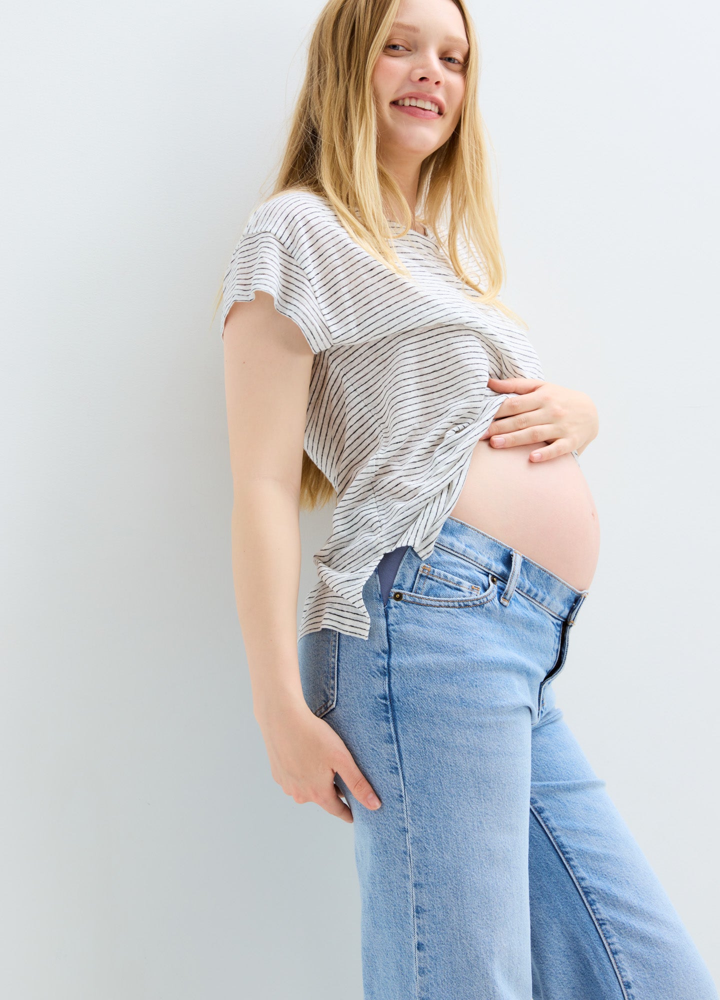 Light blue relaxed wide-leg maternity jeans with stretchy belly panel on pregnant model.