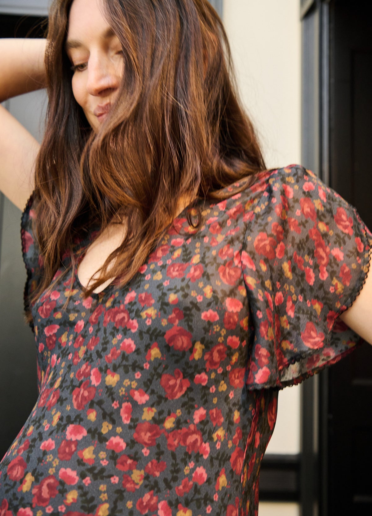 Black maternity dress with a red and green floral print, square neckline, and flutter sleeves.