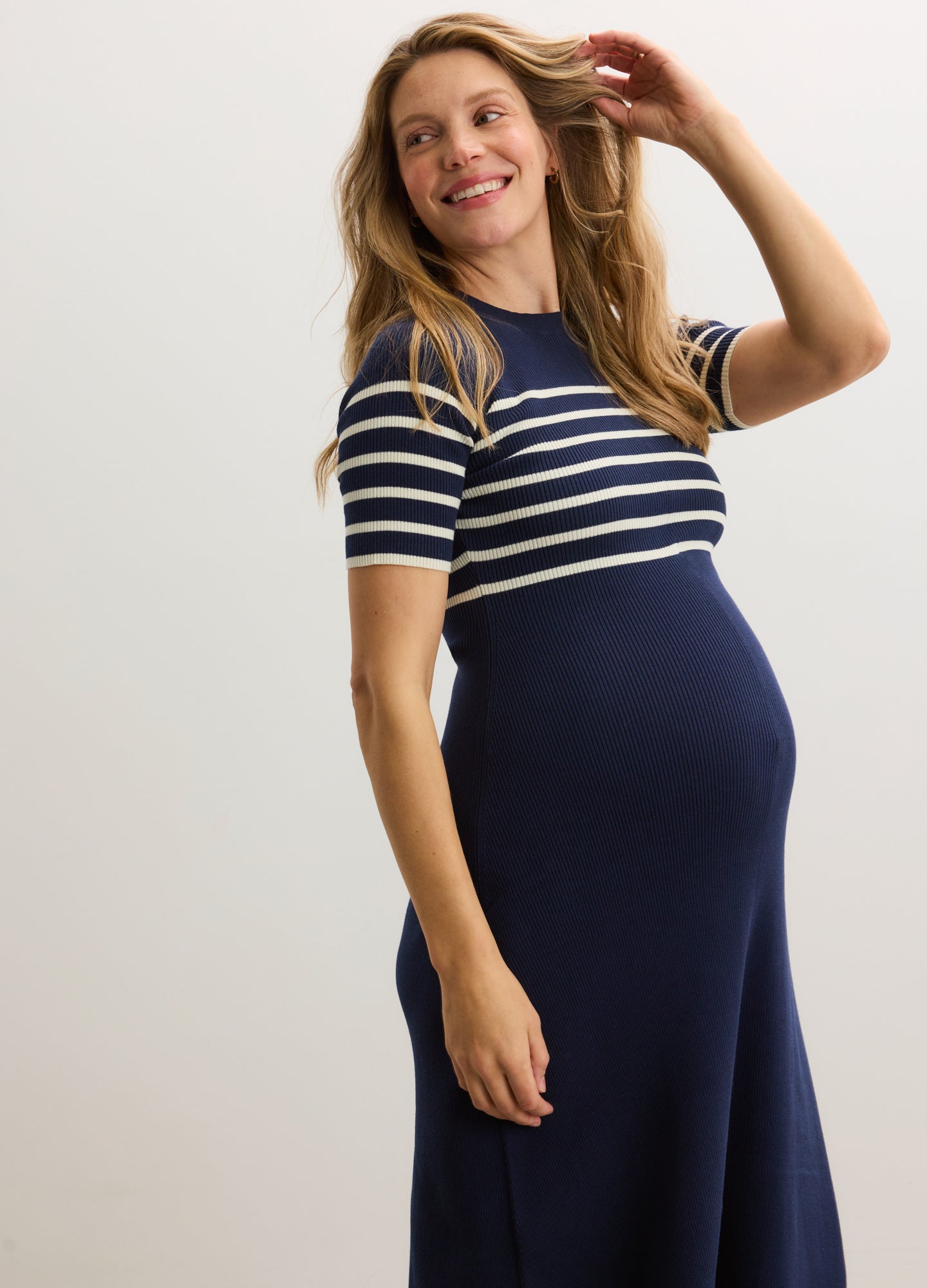 Navy blue ribbed cotton maternity dress with white horizontal stripes on short sleeves and upper chest.