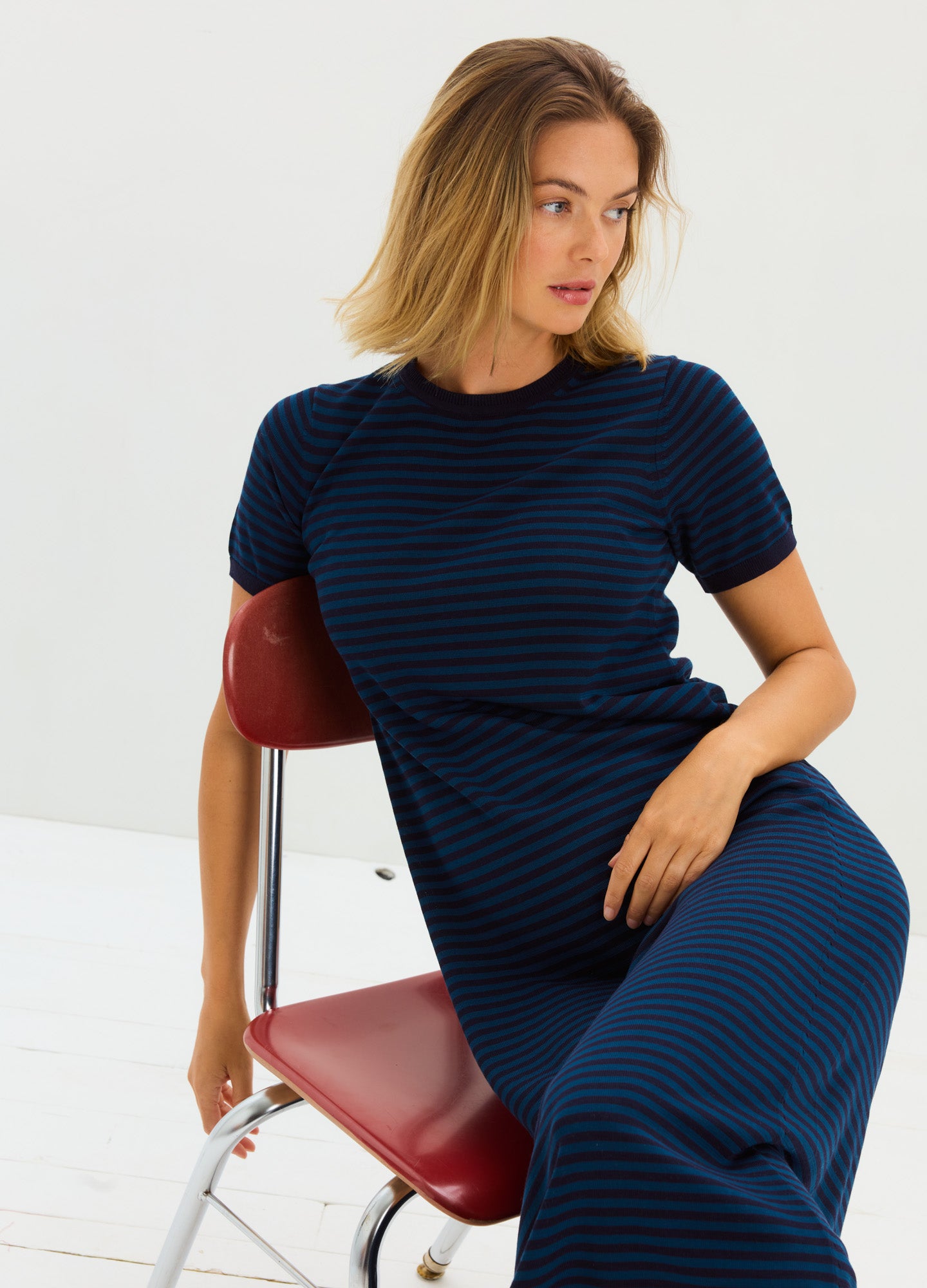 Navy blue and black striped short-sleeve knit maternity dress with a fitted silhouette and stretchy fabric designed for.