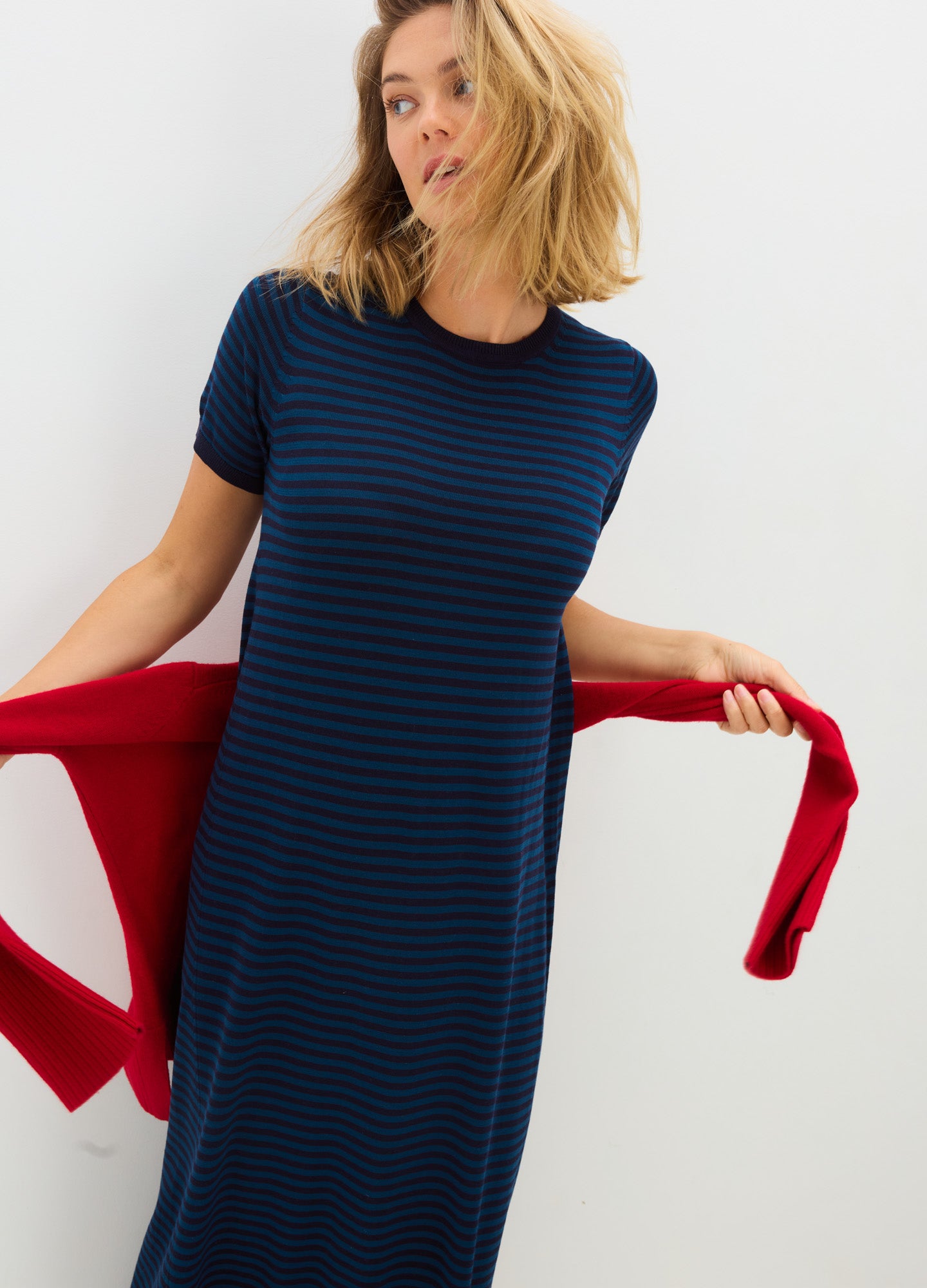 Navy blue and black striped short-sleeve knit maternity dress with a fitted silhouette and round neckline, styled for.