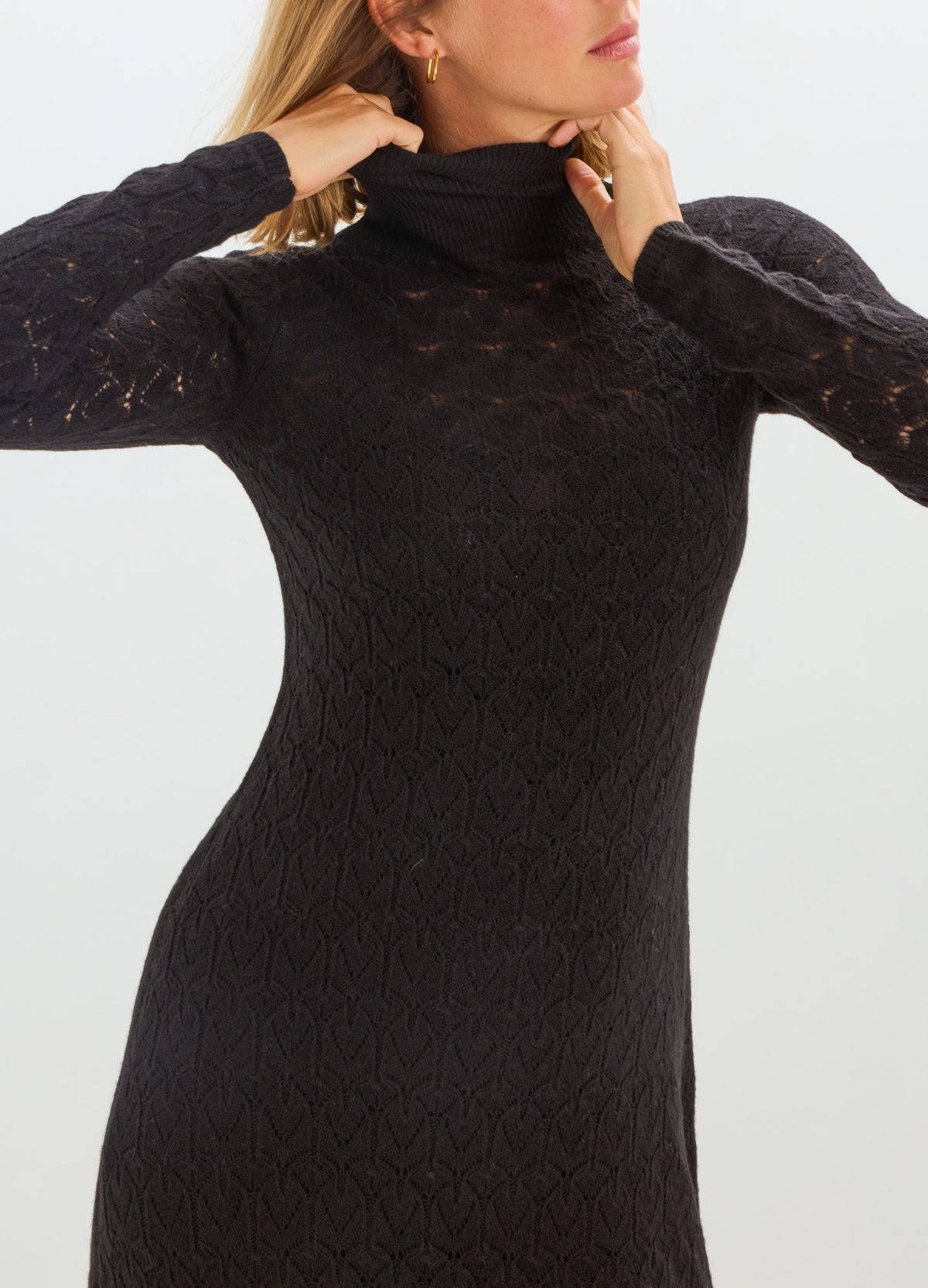 Black long-sleeve maternity dress with a high neck, fitted silhouette, and delicate pointelle knit texture.