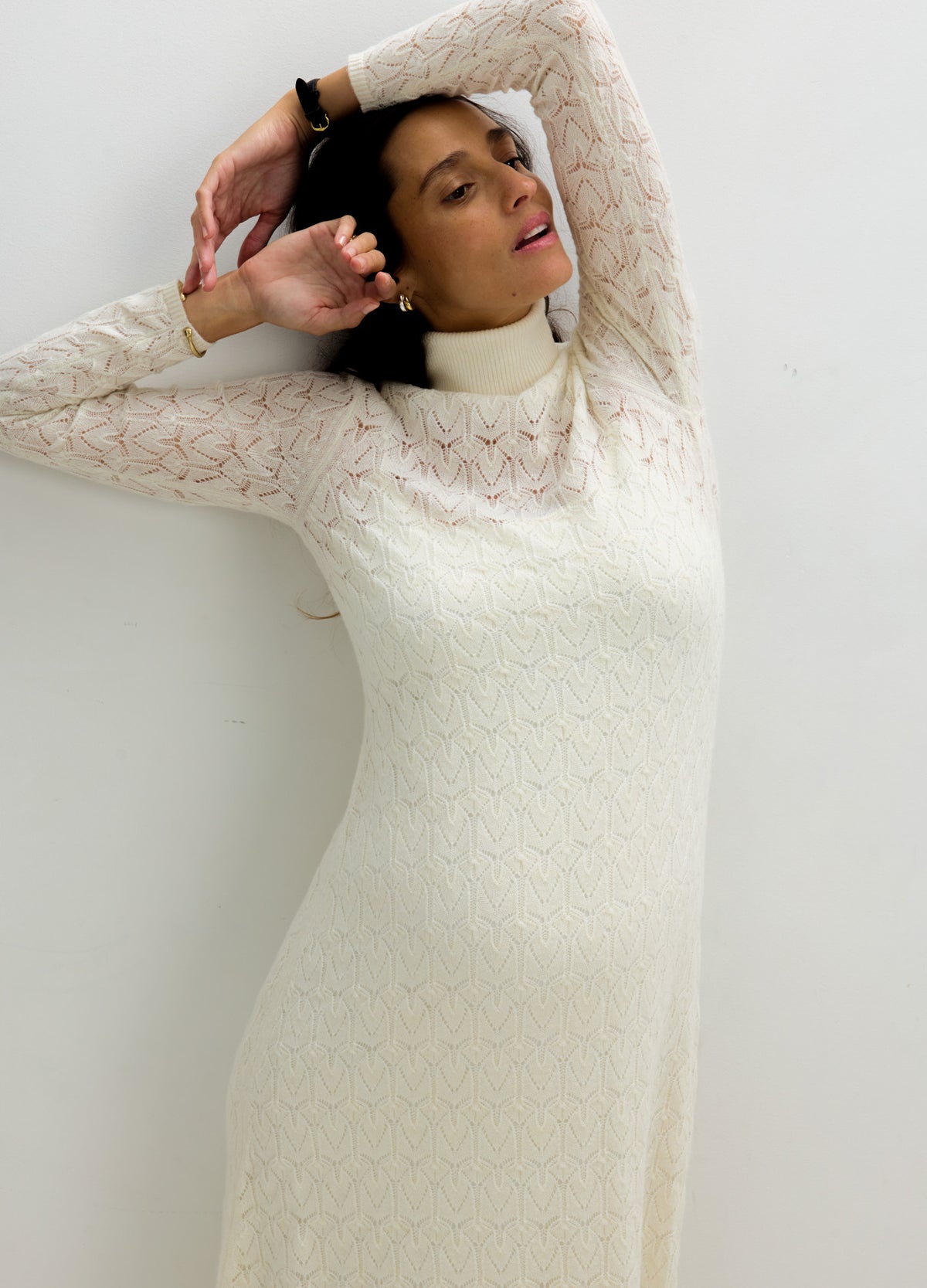Ivory long-sleeve pointelle maternity dress with a high neckline and fitted silhouette, styled for pregnancy and nursing.