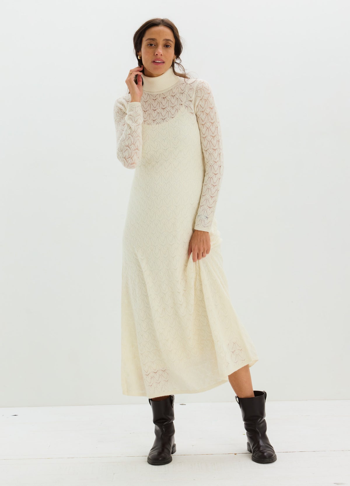 Ivory maternity dress with sheer pointelle sleeves, a fitted bodice, and flowing ankle-length skirt.