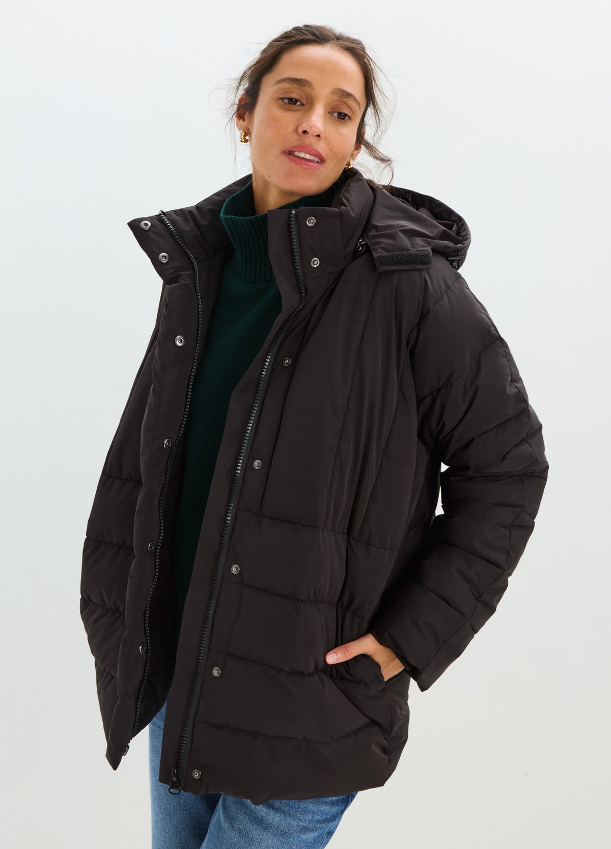 Black quilted puffer jacket with a high collar, snap-front closure, roomy pockets, and a relaxed fit.
