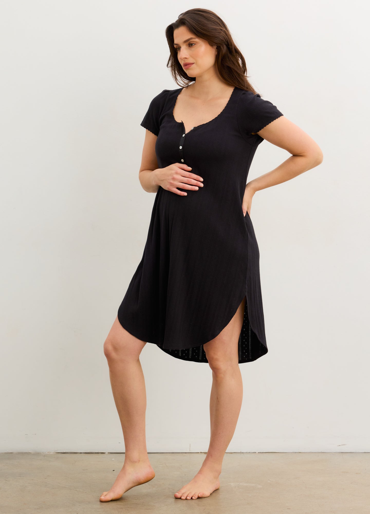 Black short-sleeve maternity nightgown with button detail and curved hem, designed for pregnant comfort.