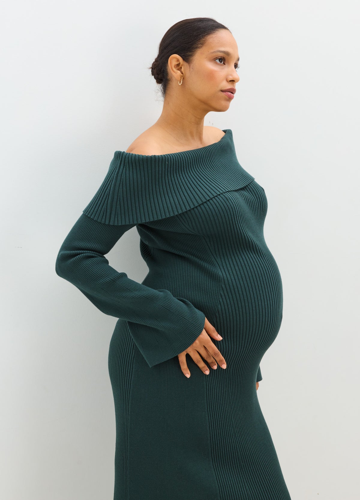 Dark green ribbed off-the-shoulder maternity sweater dress with long sleeves and a fitted shape.