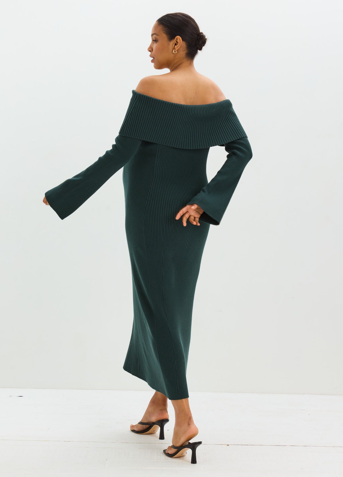 Dark green off-the-shoulder sweater dress with a folded neckline, long sleeves, and a fitted, ankle-length silhouette.