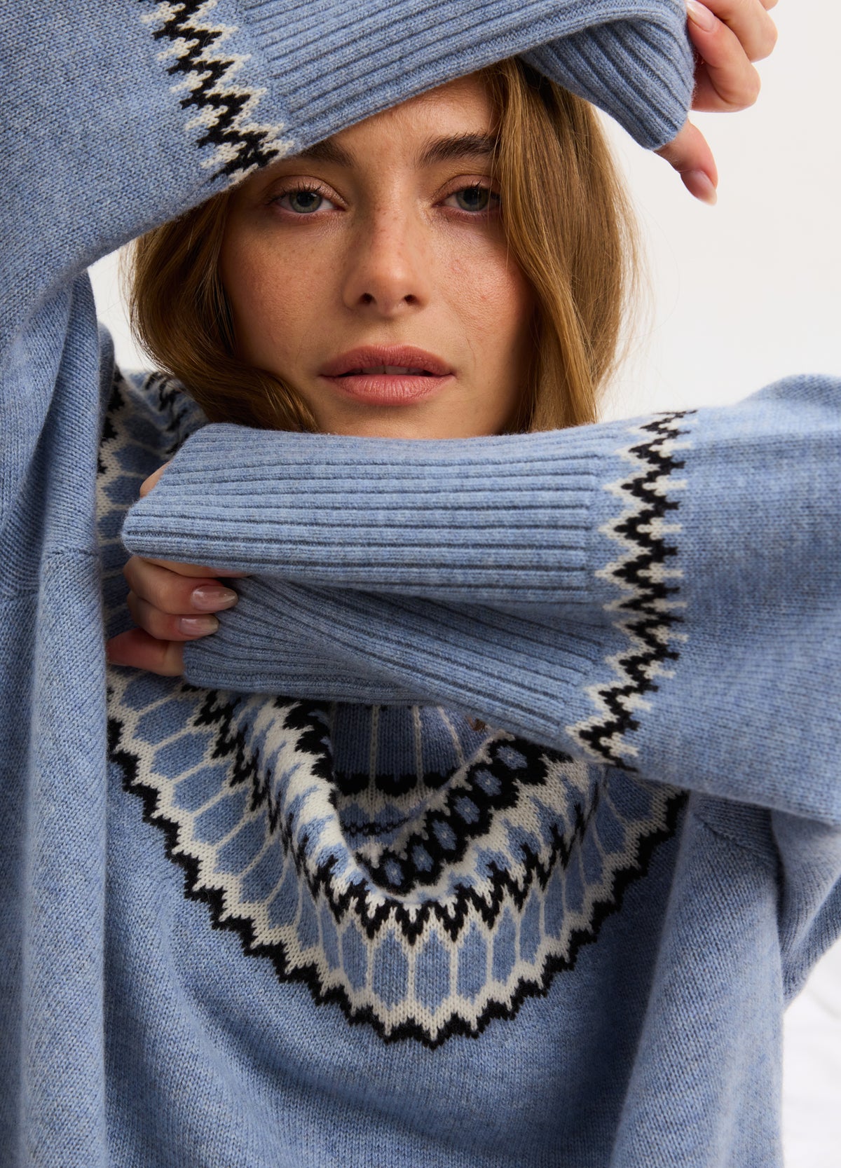 Light blue maternity pullover with fair isle pattern in white and brown around yoke and cuffs, ribbed sleeves.
