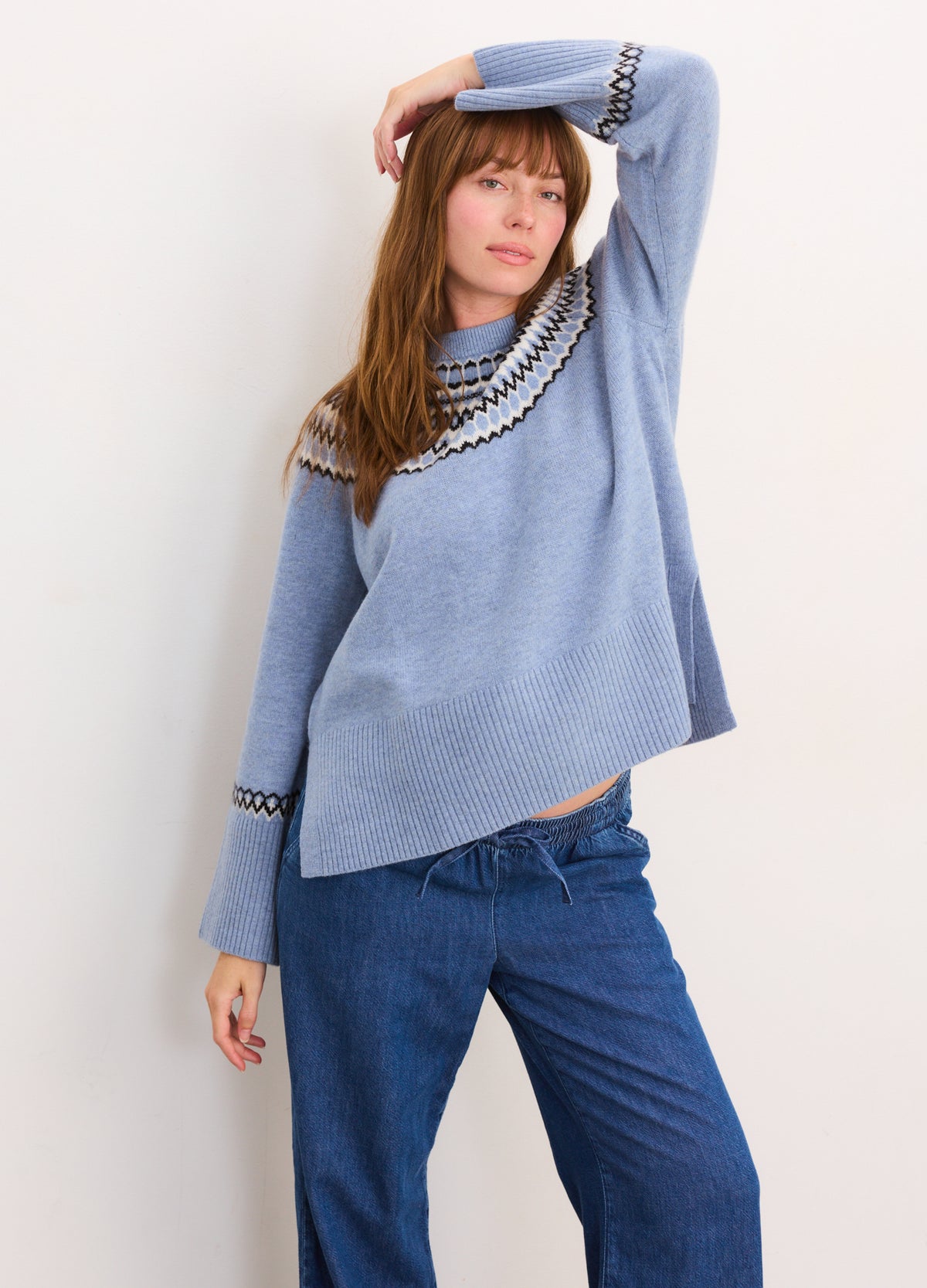 Light blue maternity pullover with black and white fair isle pattern on yoke and cuffs, relaxed fit.