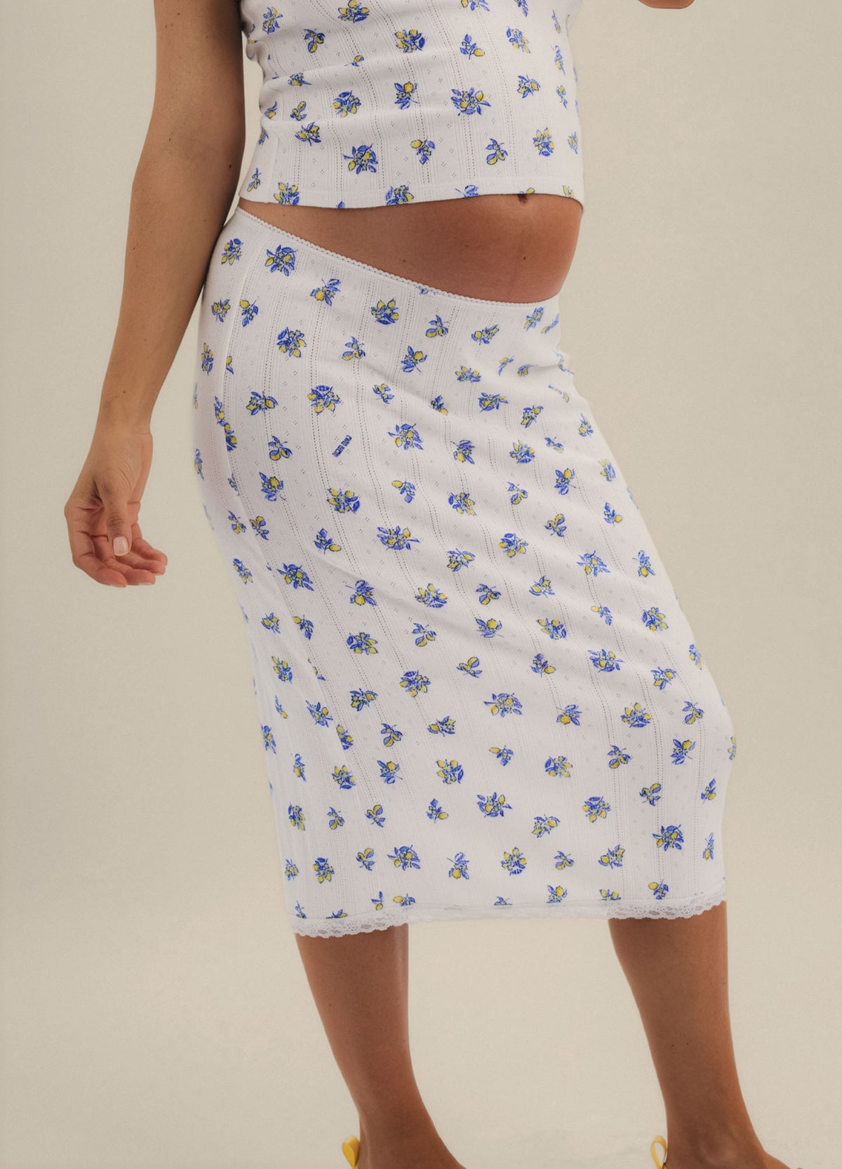 White midi maternity skirt with blue floral pointelle knit and stretchy high waistband.