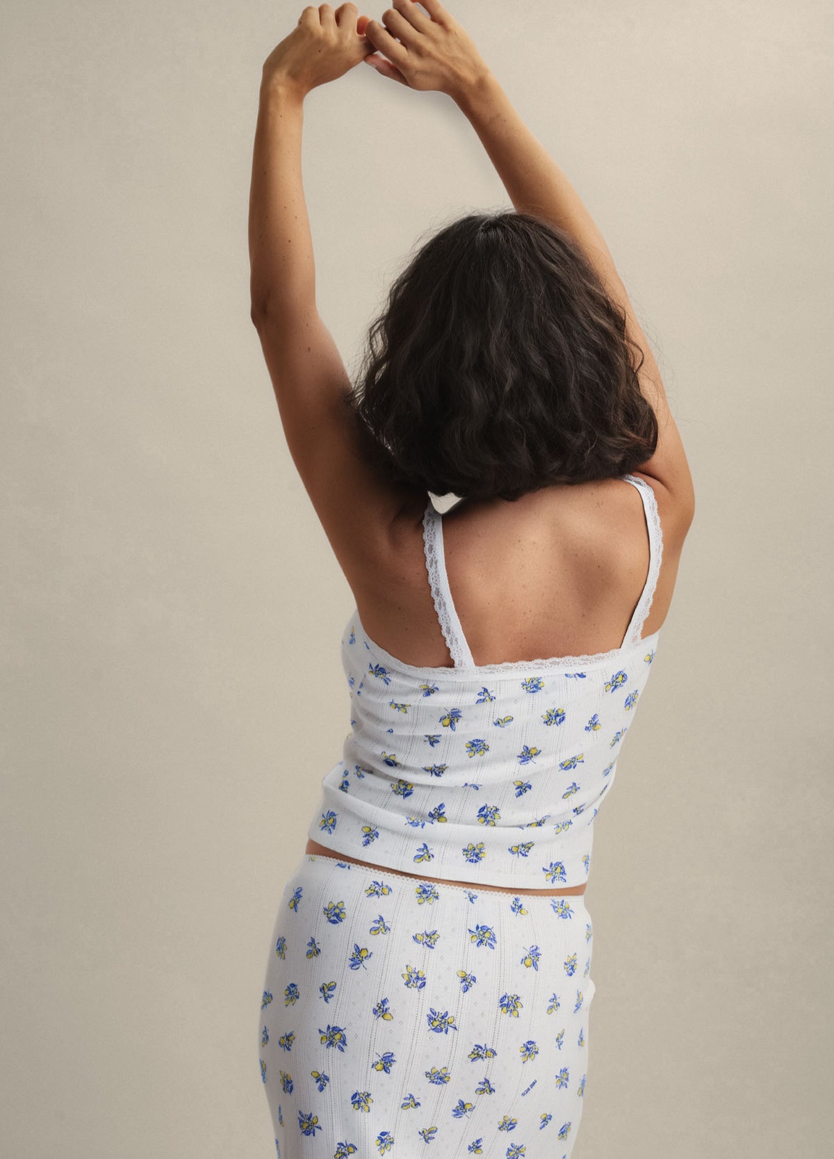 White maternity cami with blue floral pointelle knit, adjustable spaghetti straps, and fitted silhouette.