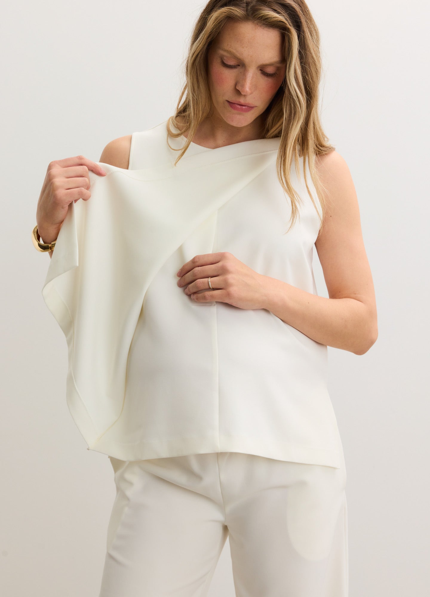 Cream-colored sleeveless maternity nursing tank with soft fabric and discreet front panel opening.